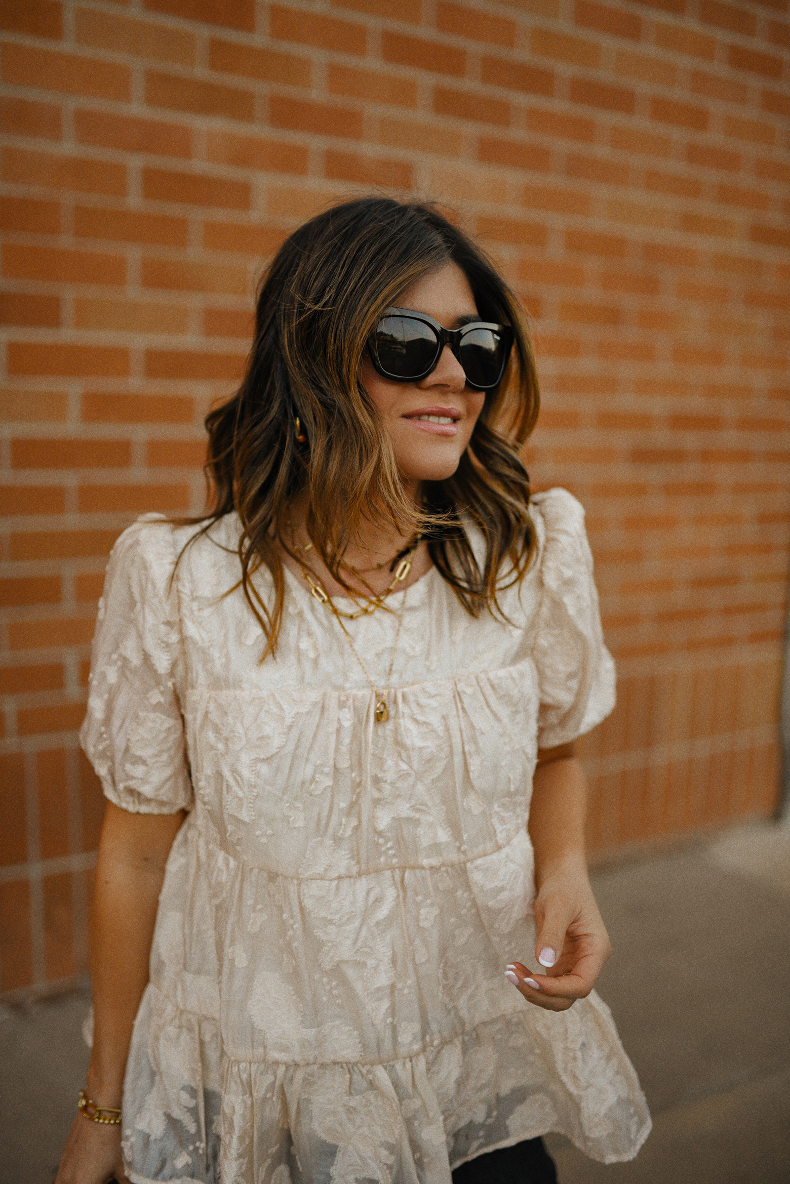 Carolina Hellal of Chic Talk wearing a floral A-line blouse, Levi's grey straight leg jeans, Quay eye cat sunglasses and Pelle moda black mules and Target pouch bag. 