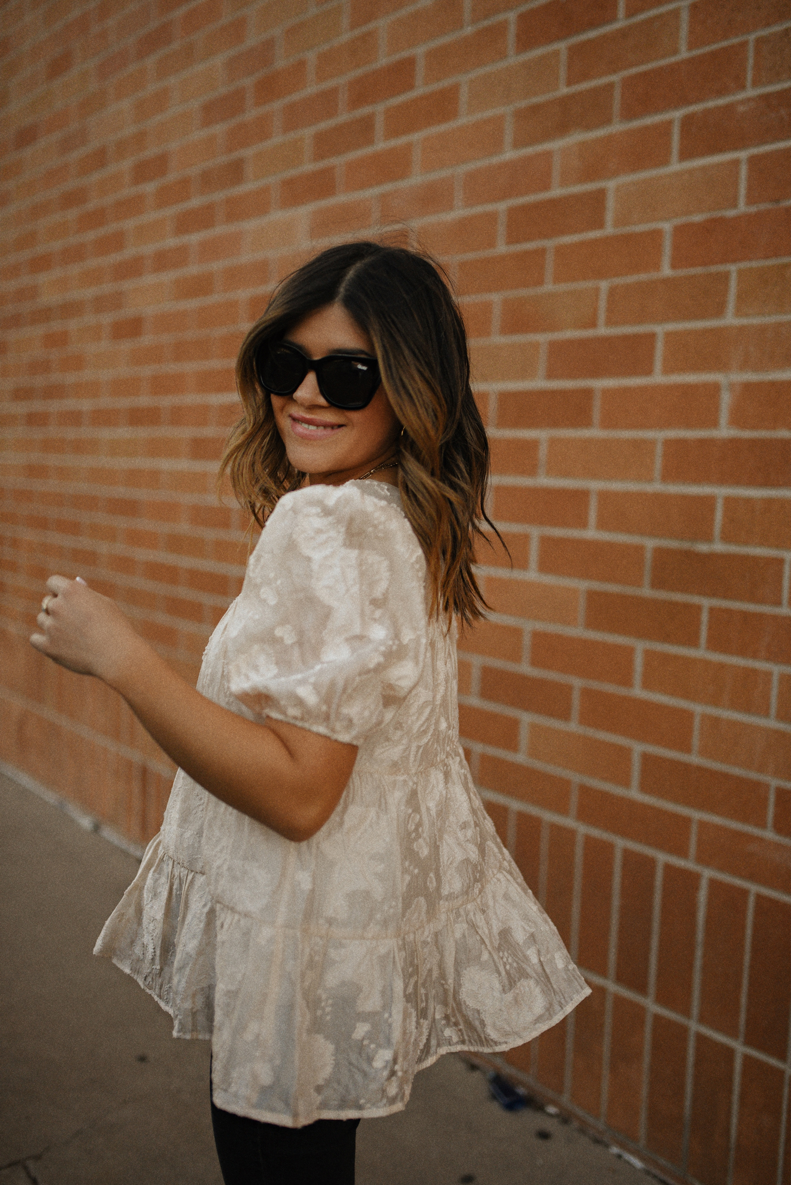 Carolina Hellal of Chic Talk wearing a floral A-line blouse, Levi's grey straight leg jeans, Quay eye cat sunglasses and Pelle moda black mules and Target pouch bag. 