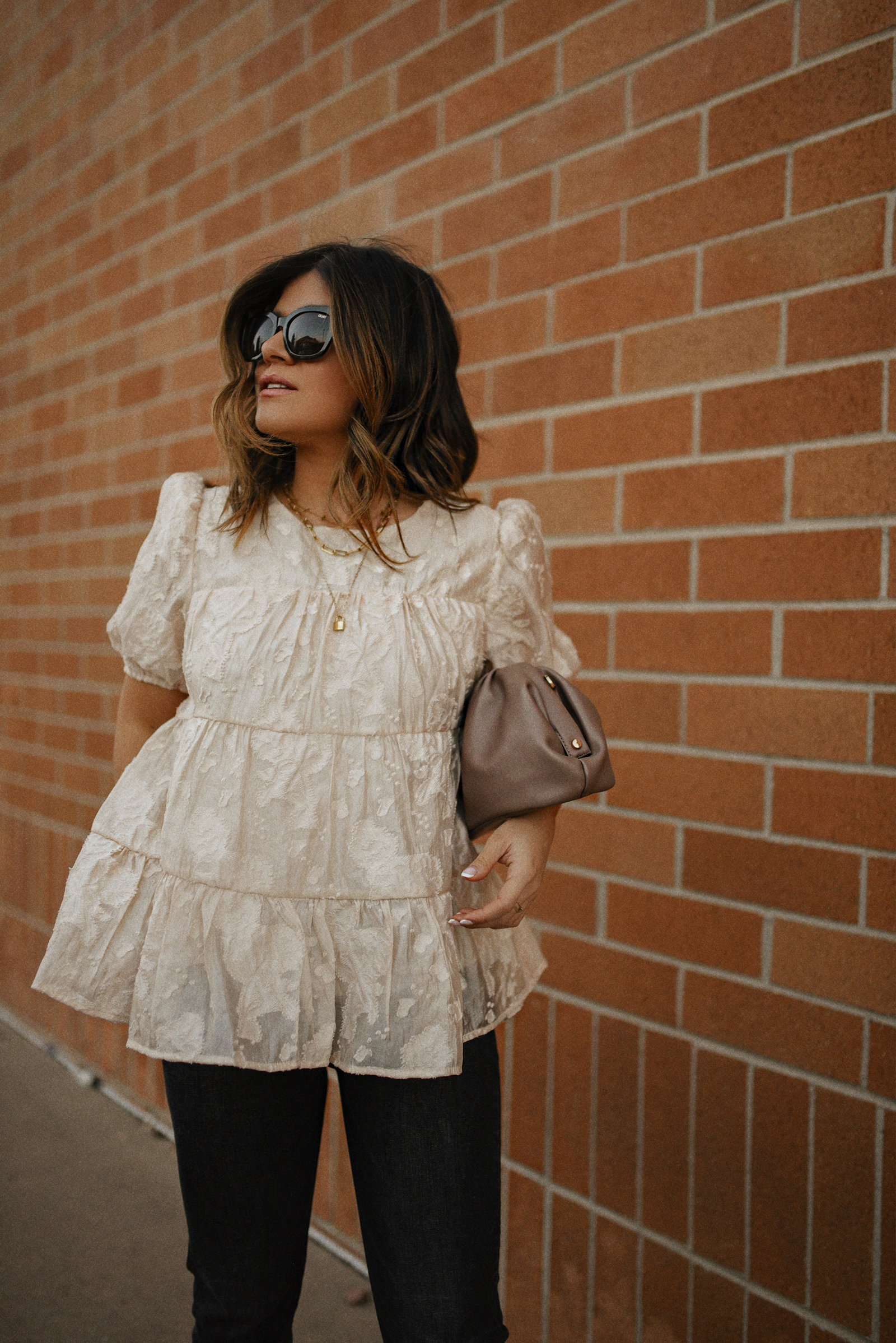 Carolina Hellal of Chic Talk wearing a floral A-line blouse, Levi's grey straight leg jeans, Quay eye cat sunglasses and Pelle moda black mules and Target pouch bag. 