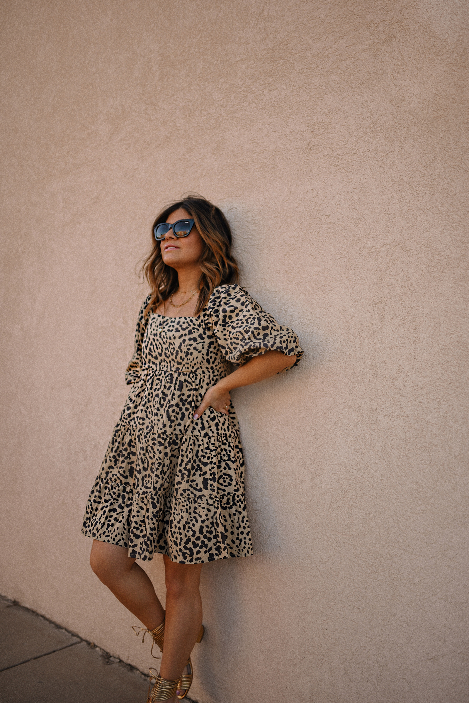 Carolina Hellal of Chic Talk wearing a Cheetah print dress via Anthropologie, Cecelia New York gold sandals, Quay eye cat sunglasses and JW Pei brown bag. 