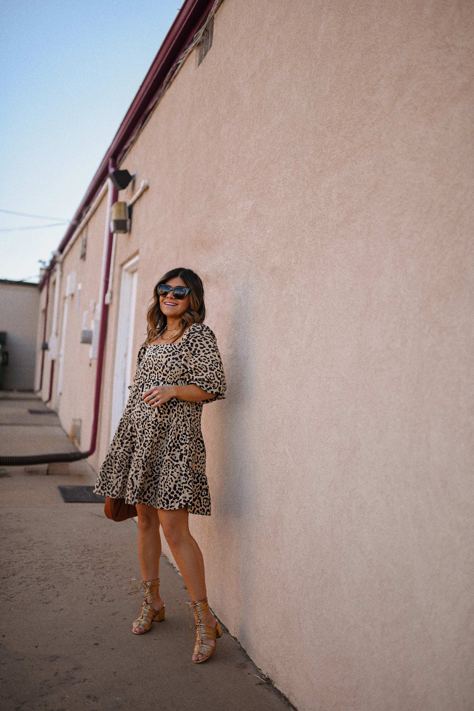 Carolina Hellal of Chic Talk wearing a Cheetah print dress via Anthropologie, Cecelia New York gold sandals, Quay eye cat sunglasses and JW Pei brown bag. 