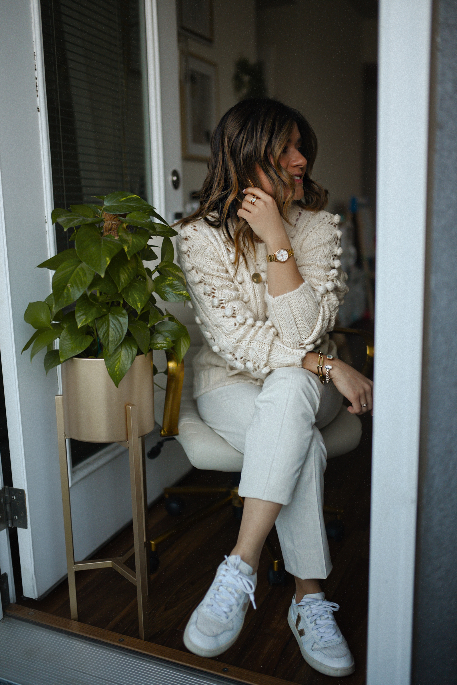 Carolina Hellal of Chic Talk wearing a Goodnight Macaroon pom pom sweater, Uniqlo beige trousers and Veja sneakers.
