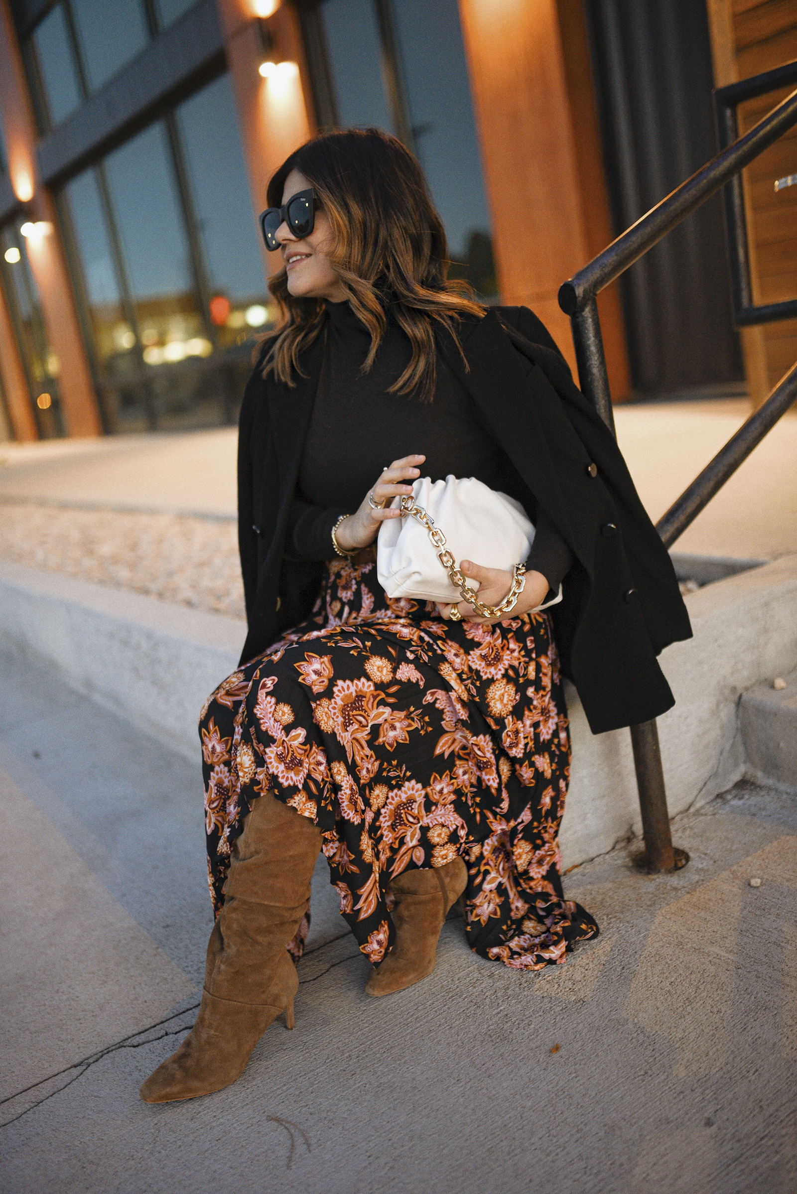 Carolina Hellal of Chic Talk wearing an H&M black blazer, turtleneck sweater, QUAY sunglasses, The Get via Walmart floral Maxi skirt and Vince Camuto suede tall boots