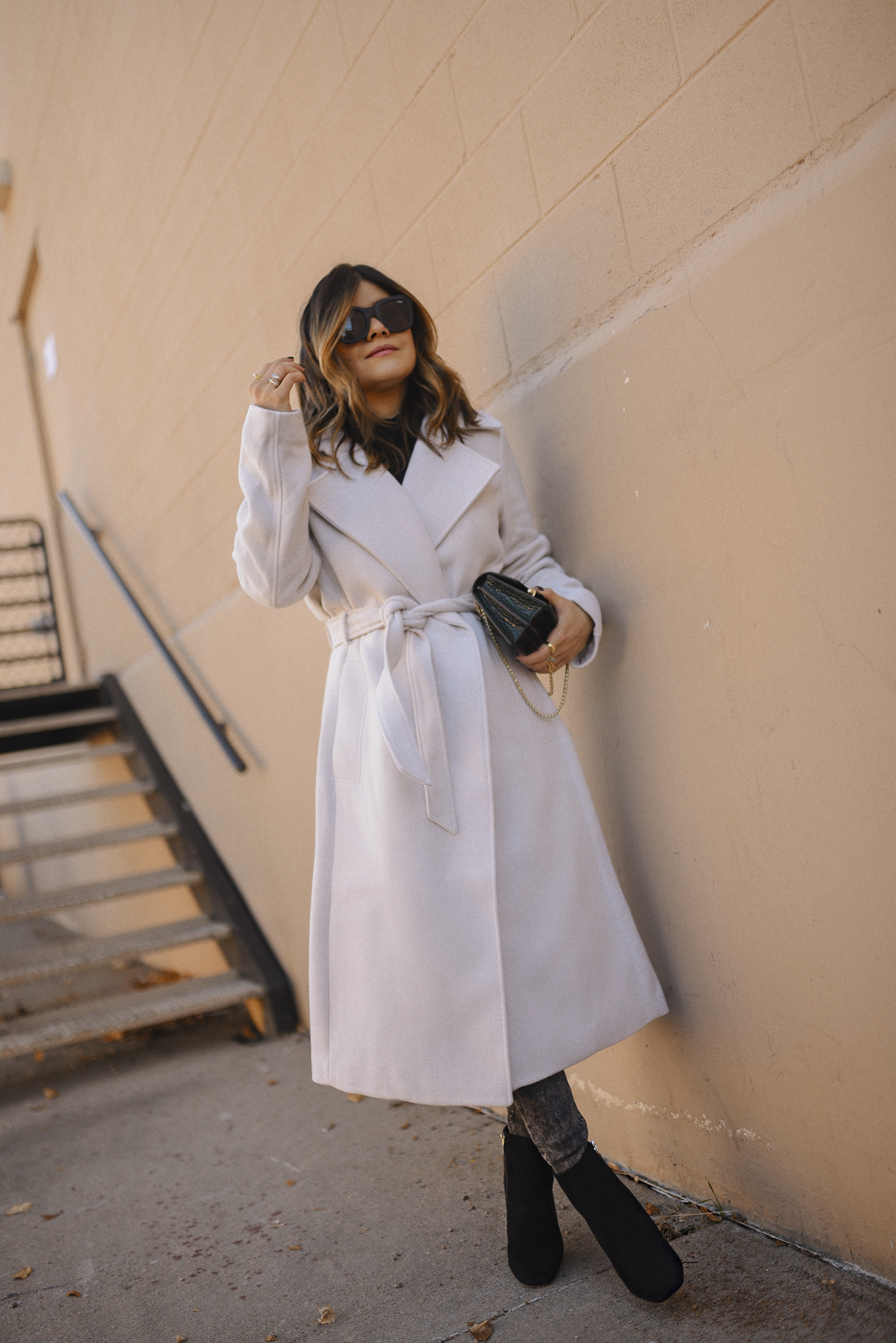 Carolina Hellal of Chic Talk wearing an H&M white coat, Express skinny jeans, Vince Camuto black booties and Quay afterhours sunglasses