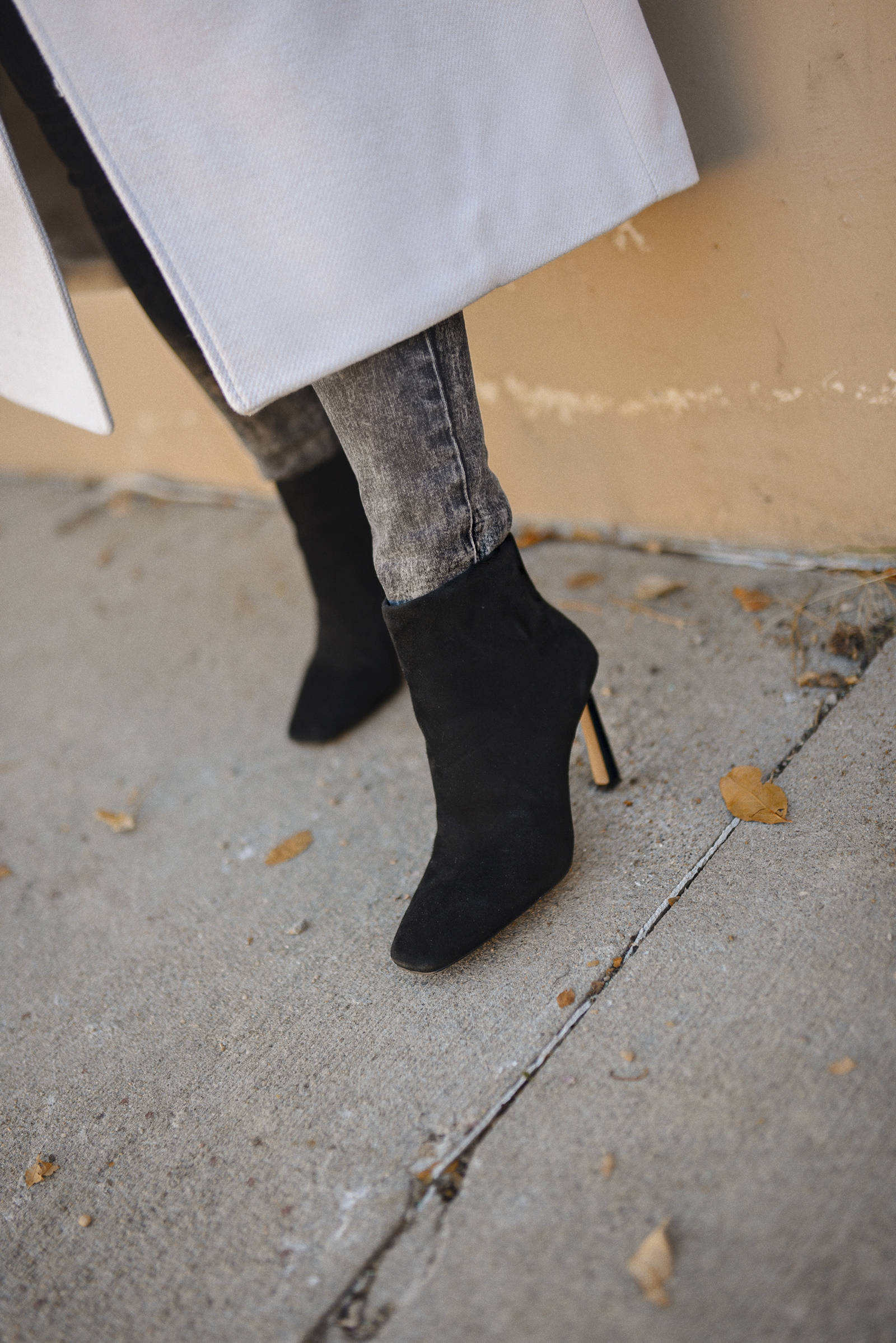 Carolina Hellal of Chic Talk wearing an H&M white coat, Express skinny jeans, Vince Camuto black booties and Quay afterhours sunglasses