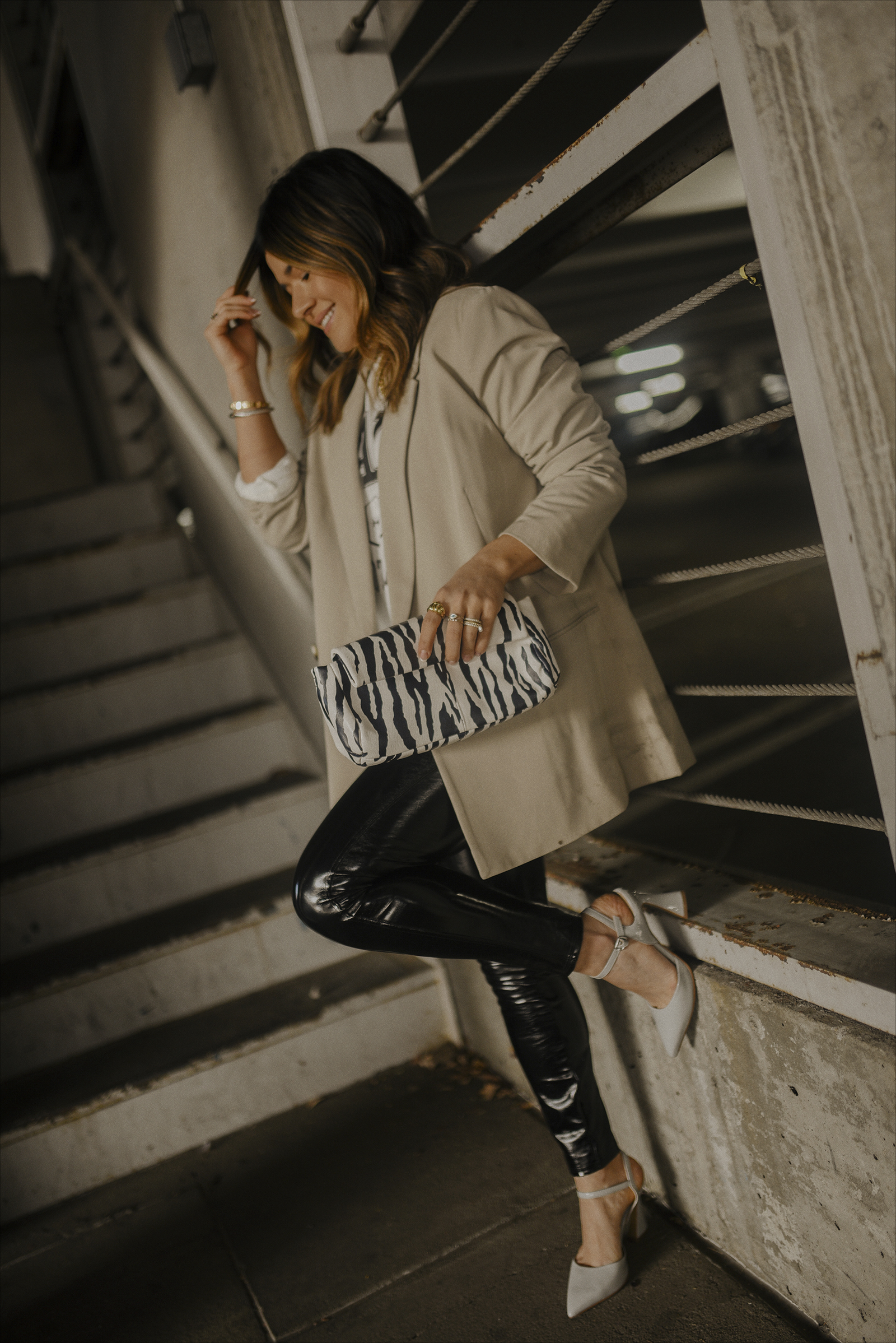 Carolina Hellal of Chic Talk wearing an H&M graphic tee and blazer, spanx liquid leggings and Vince Camuto heels and zebra print bag.