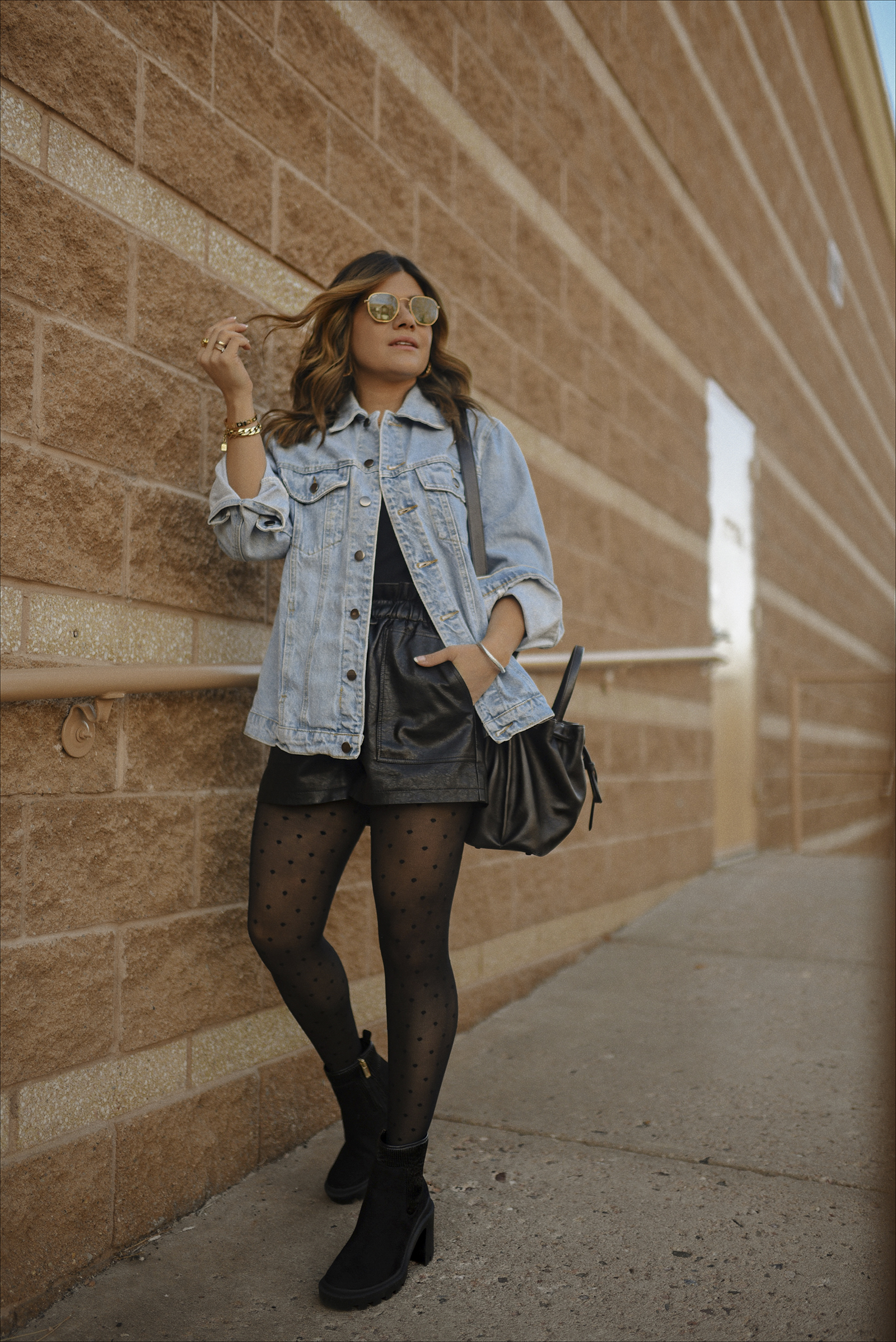 Carolina Hellal of Chic Talk wearing a Denim jacket, faux leather shorts via Amazon, JLO Jennifer lopez chunky boots and Cole Haan bucket bag