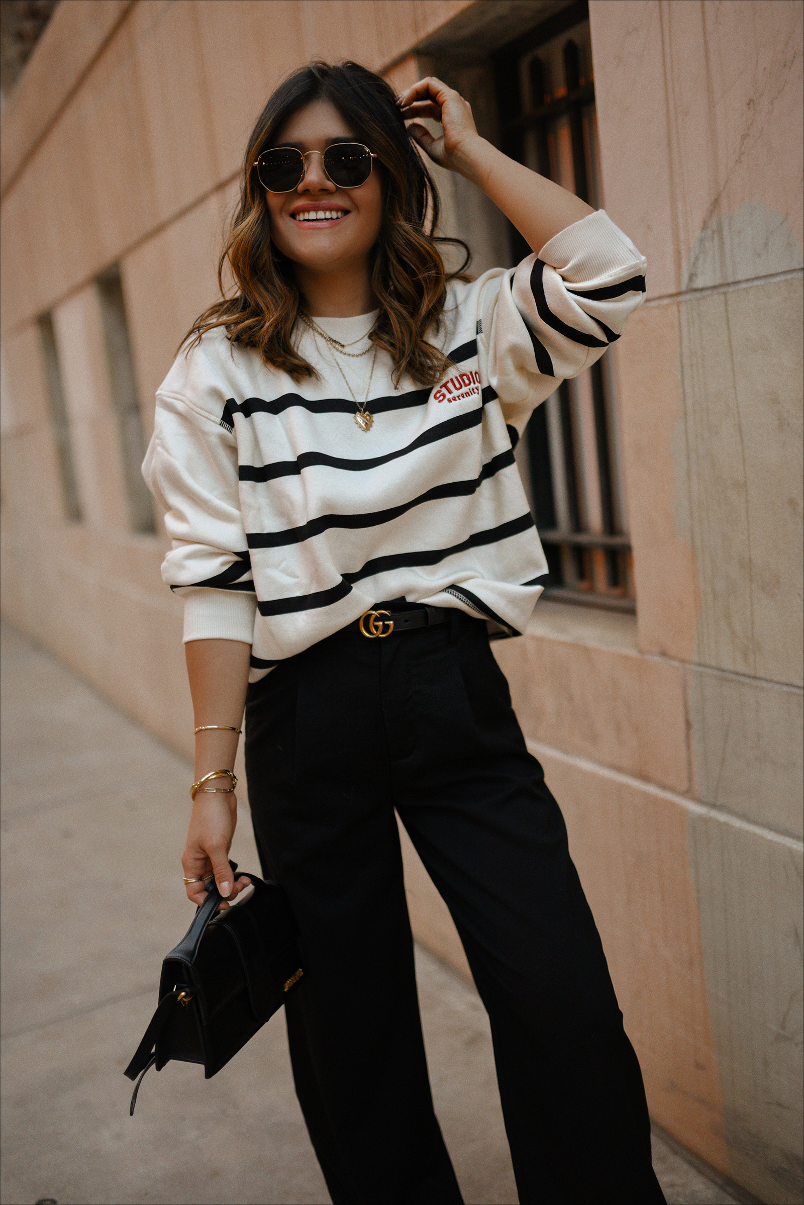 Carolina Hellal of Chic Talk wearing an h&m sweatshirt, and black trousers, platform converse and a Jacquemus bag. 