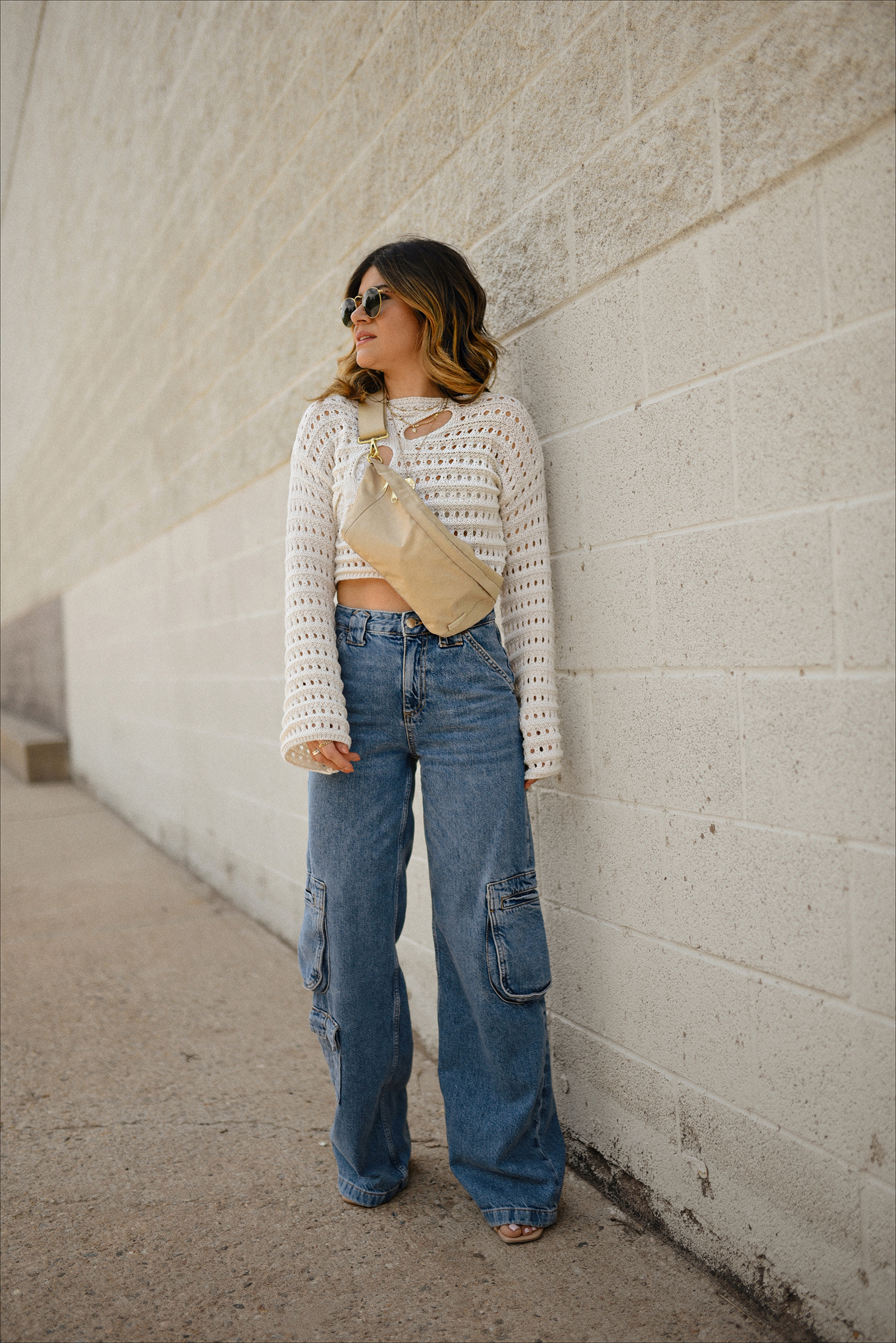 https://chictalkch.com/wp-content/uploads/2023/06/Carolina-Hellal-of-Chic-Talk-wearing-denim-cargo-jeans-for-summer-via-Mango-knit-sweater-from-Amazon-fashion-and-a-fanny-pack-via-Canvelle-1.jpg