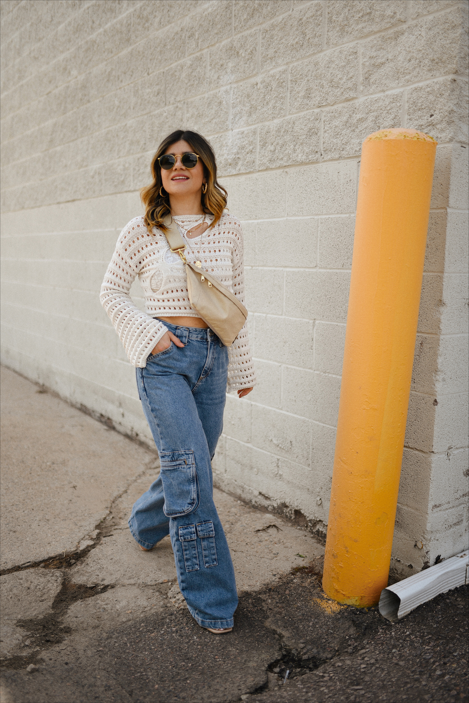 Carolina Hellal of Chic Talk wearing denim cargo jeans for summer via Mango, knit sweater from Amazon fashion, and a fanny pack via Canvelle