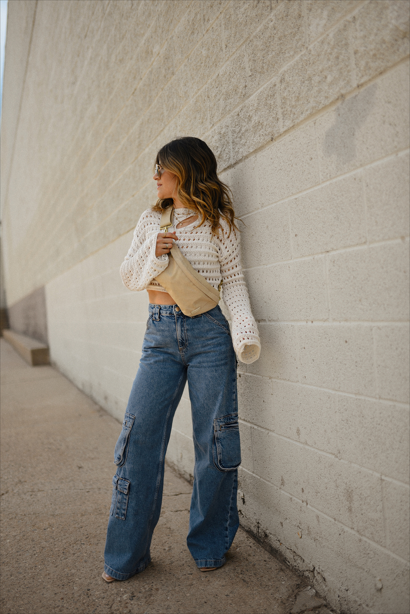 Carolina Hellal of Chic Talk wearing denim cargo jeans for summer via Mango, knit sweater from Amazon fashion, and a fanny pack via Canvelle
