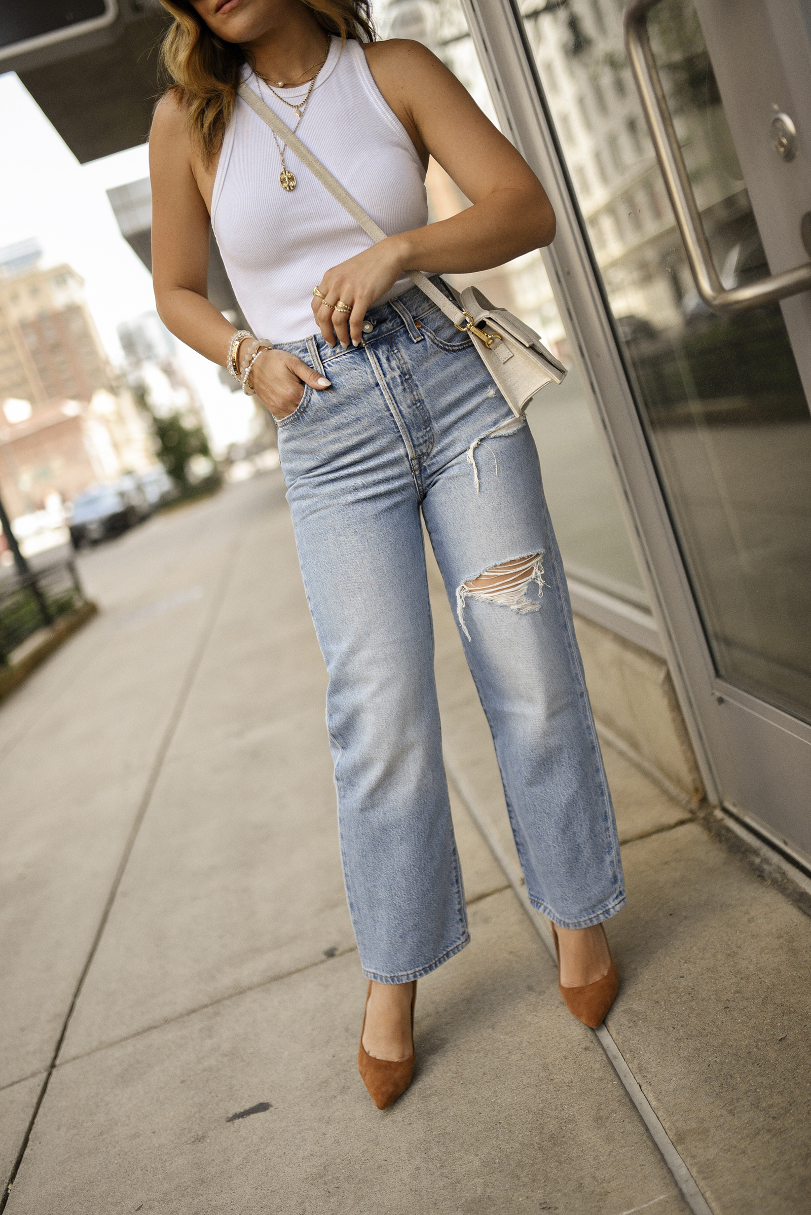 Carolina Hellal of Chic Talk wearing a white tank top via Abercrombie, Levi's straight leg jeans, steve madden suede pumps, Celine Sunglasses and Jacquemus bag. 
