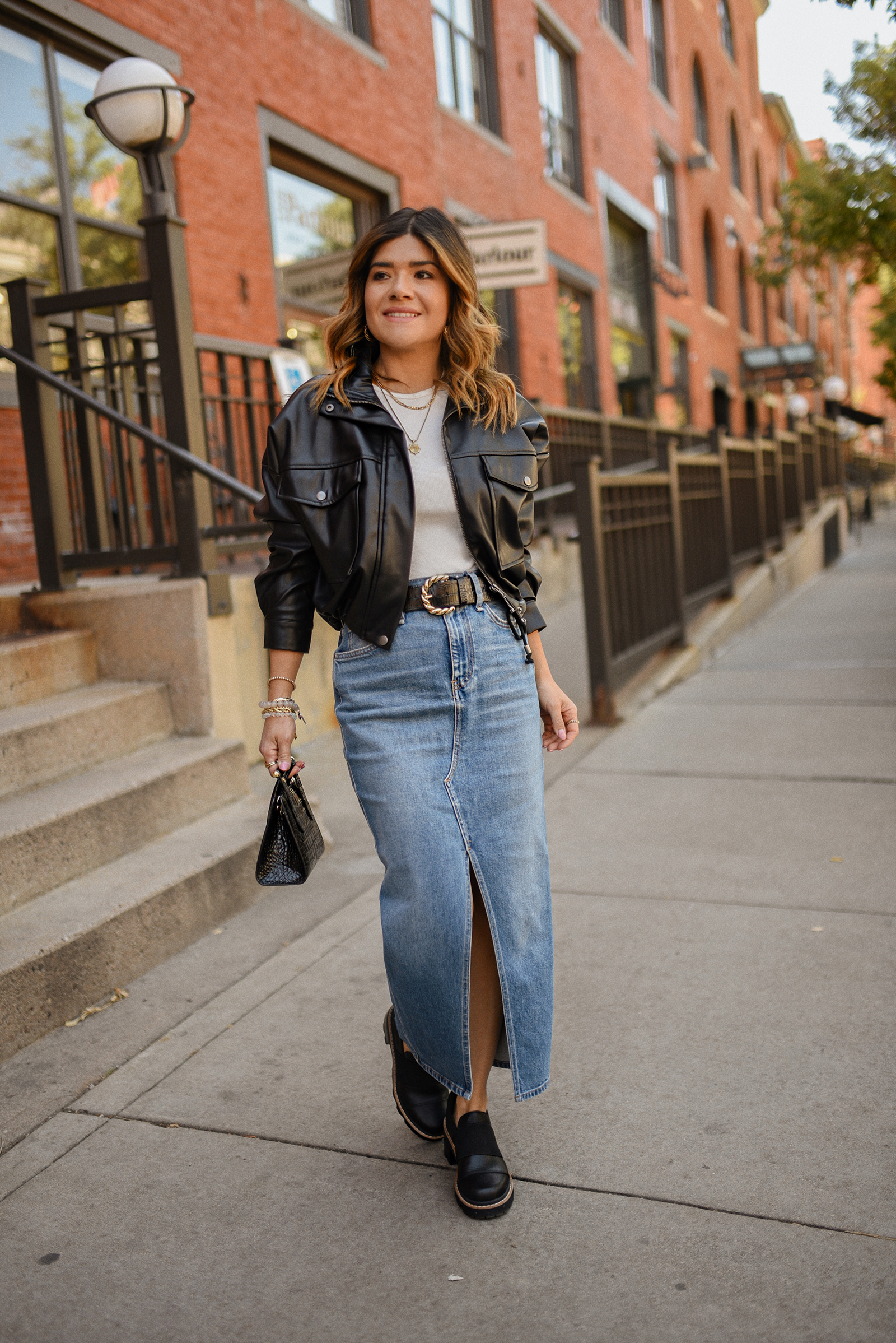 CAROLINA HELLAL FROM CHIC TALK WEARING A HUDSON DENIM MAXI SKIRT, LEATHER BOMBER JACKET AND SOREL JOAN LOAFERS.