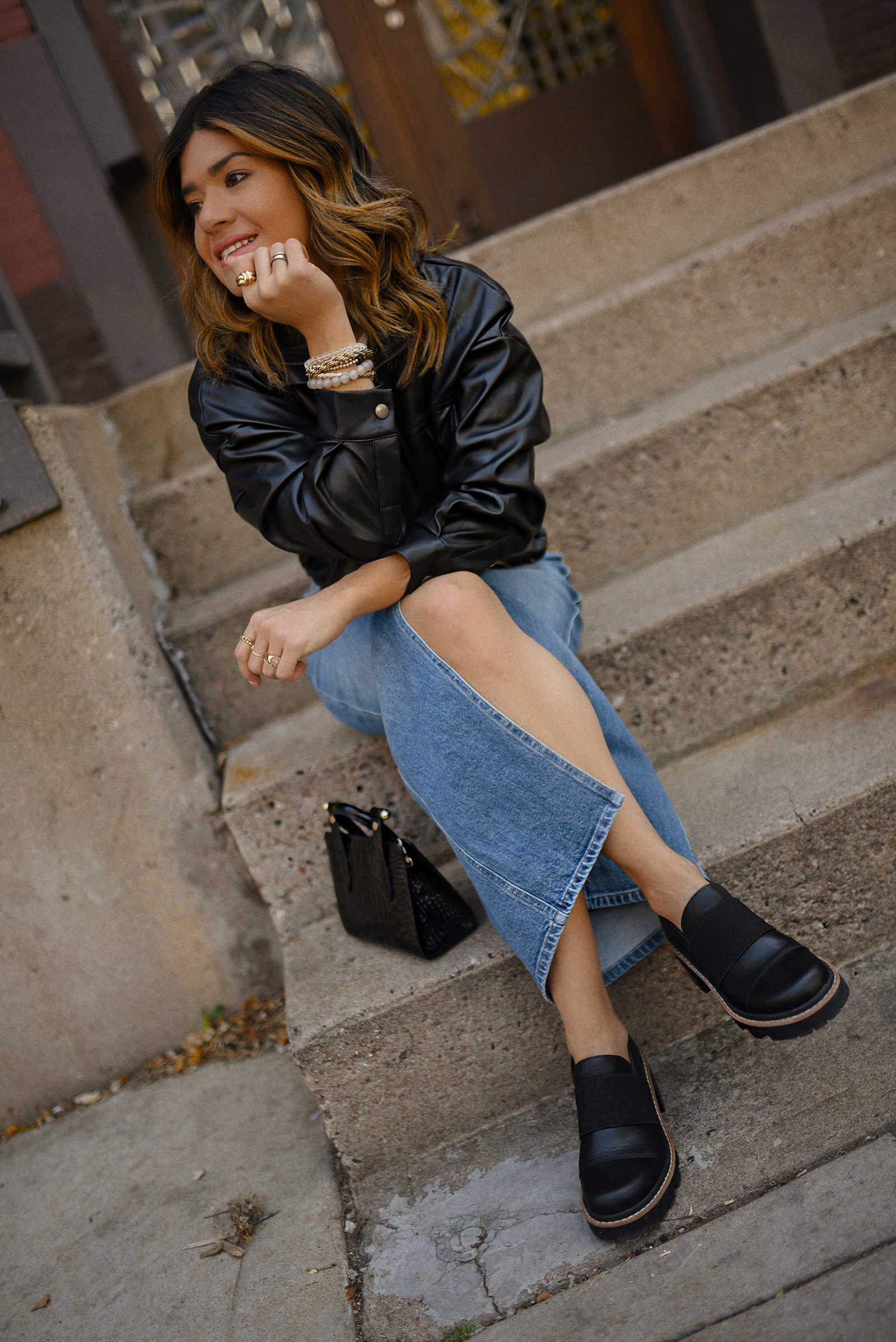 CAROLINA HELLAL FROM CHIC TALK WEARING A HUDSON DENIM MAXI SKIRT, LEATHER BOMBER JACKET AND SOREL JOAN LOAFERS. 