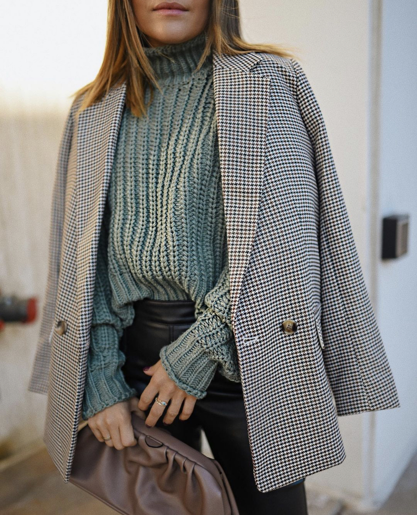 CAROLINA HELLAL FROM CHIC TALK WEARING A SAGE GREEN SWEATER AND PLAID BLACK AND WHITE BLAZER
