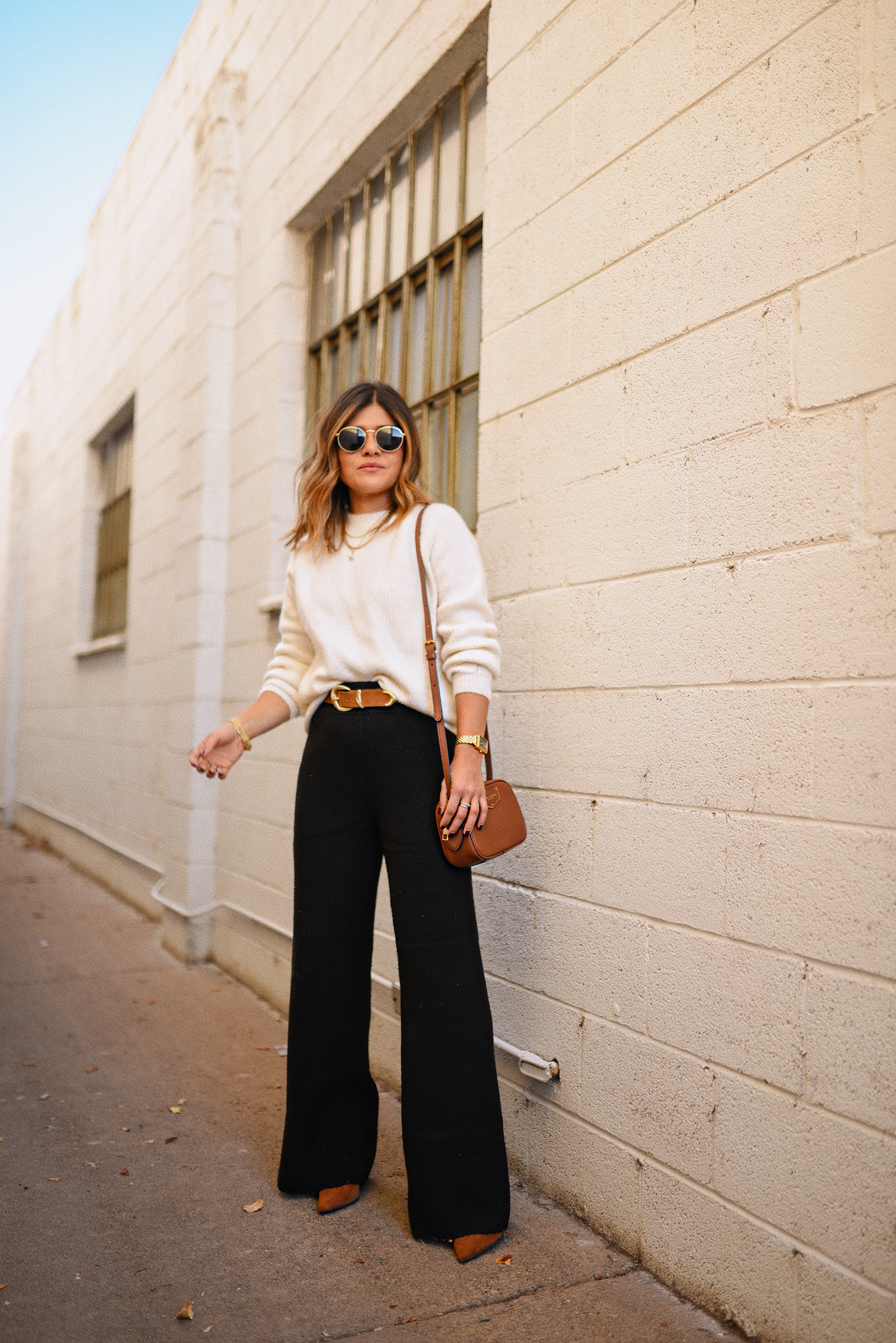 CAROLINA HELLAL FROM CHIC TALK WEARING A BLACK WIDE LEG PANTS AND WHITE SWEATER