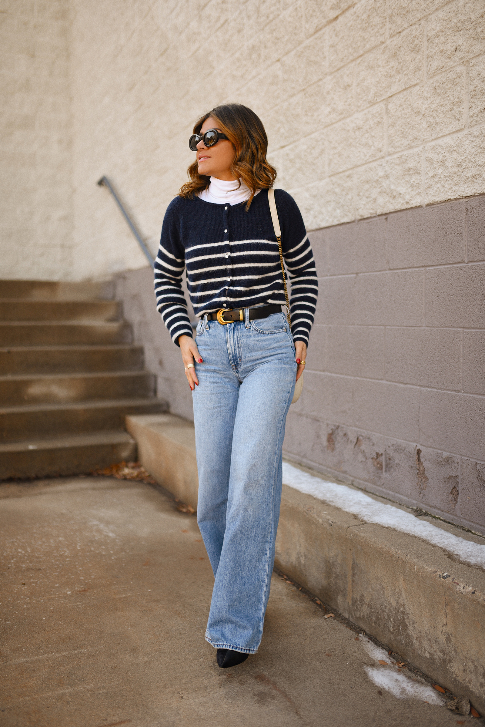 Carolina Hellal of Chic Talk wearing a Stripped cardigan from Sèzane, Madewell wide leg jeans and Yves Saint Laurent crossbody round camera bag
