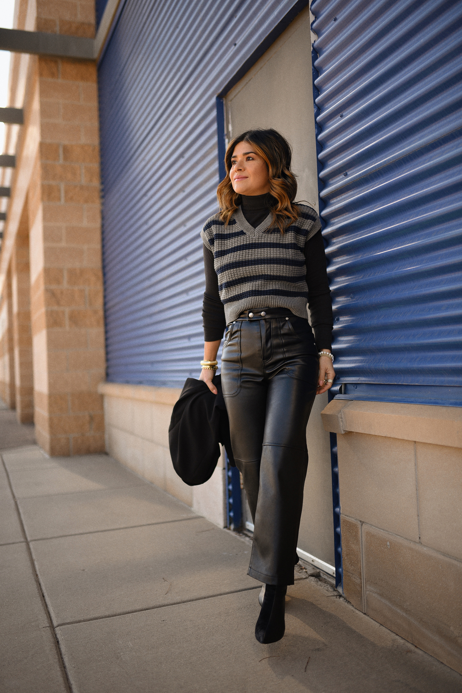 Carolina Hellal of Chic Talk wearing a faux leather pants from BLANKNYC via SHOPBOP, a Madewell knitted vest, a black blazer, a Strathberry leather tote and black booties
