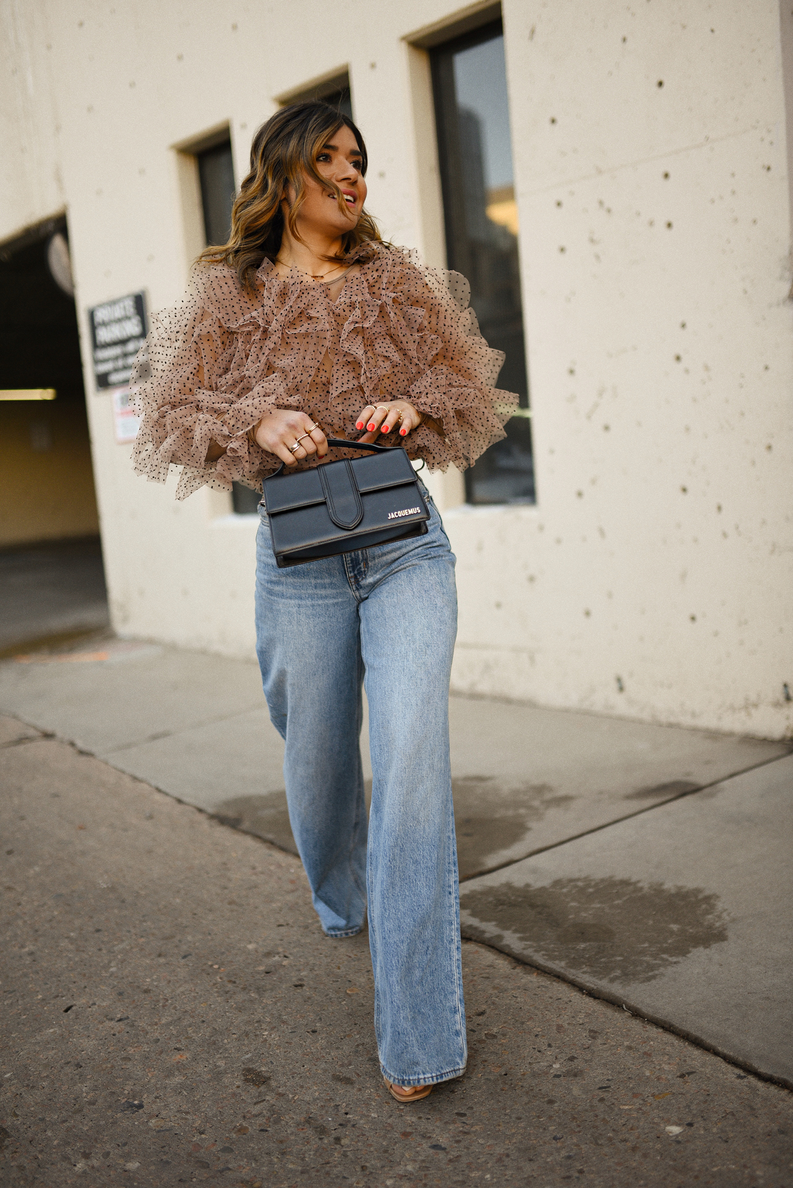 Carolina Hellal of Chic Talk wearing a statement blouse from Anthropologie, wide leg jeans from Nordstrom and Jacquemus Le Grand Bambino bag