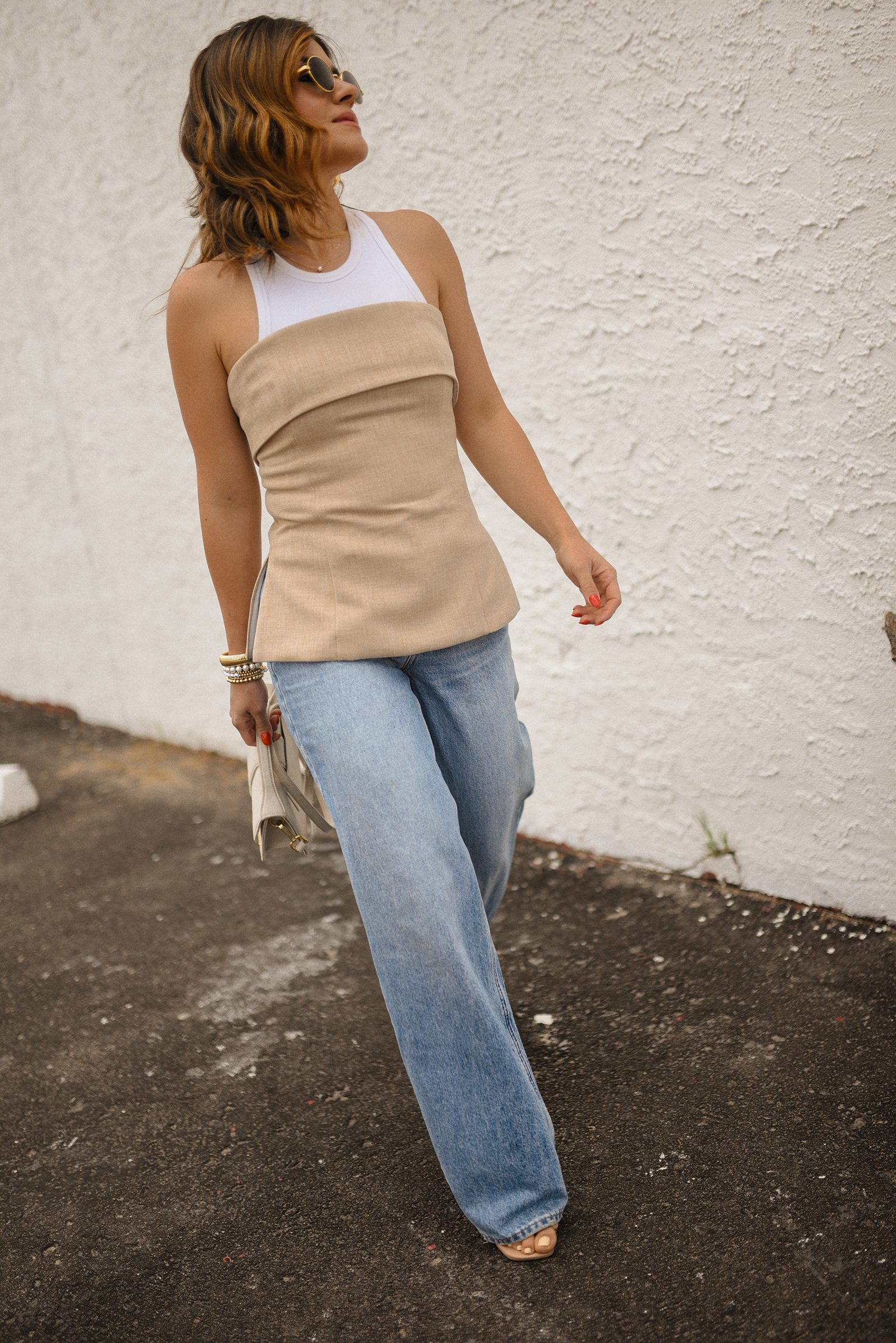 Carolina Hellal of Chic Talk wearing a Aritzia tube top and tank top, a wide leg jeans via Madewell and a Jacquemus hand bag