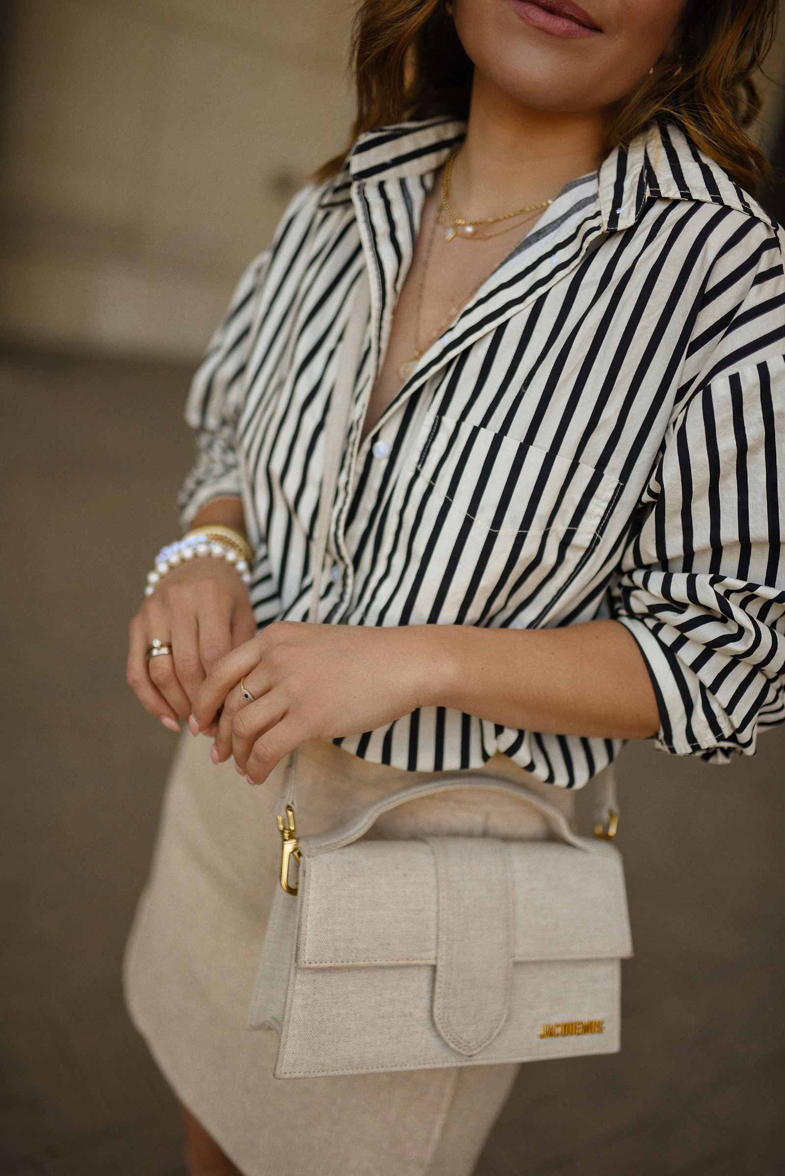 Carolina Hellal of Chic Talk wearing a Sezane mini skirt, H&M striped shirt and Jacquemus bag