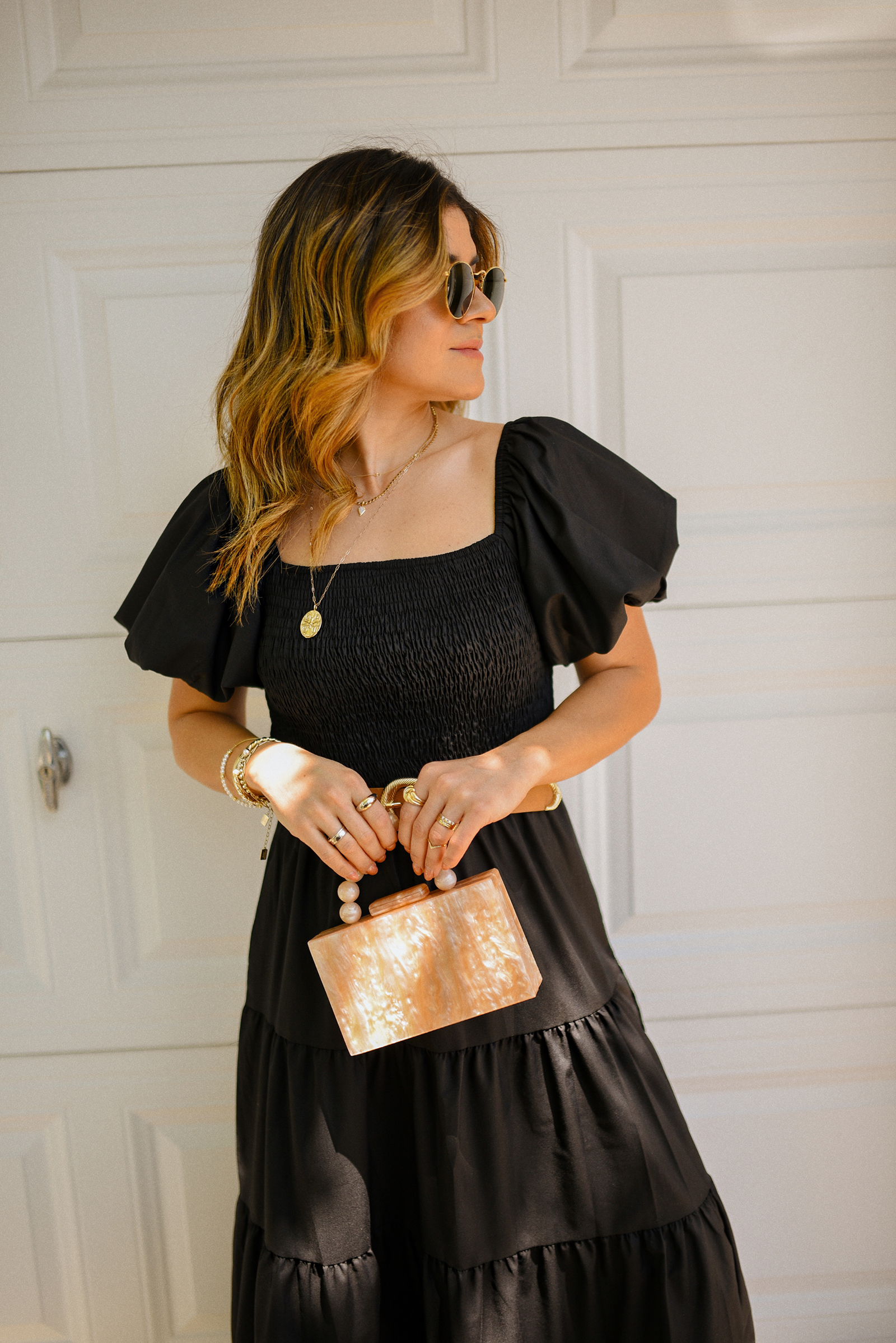 Carolina Hellal of Chic Talk wearing a blak maxi dress via Amazon, braided brown sandals, box hand bag and Ray-Ban sunglasses
