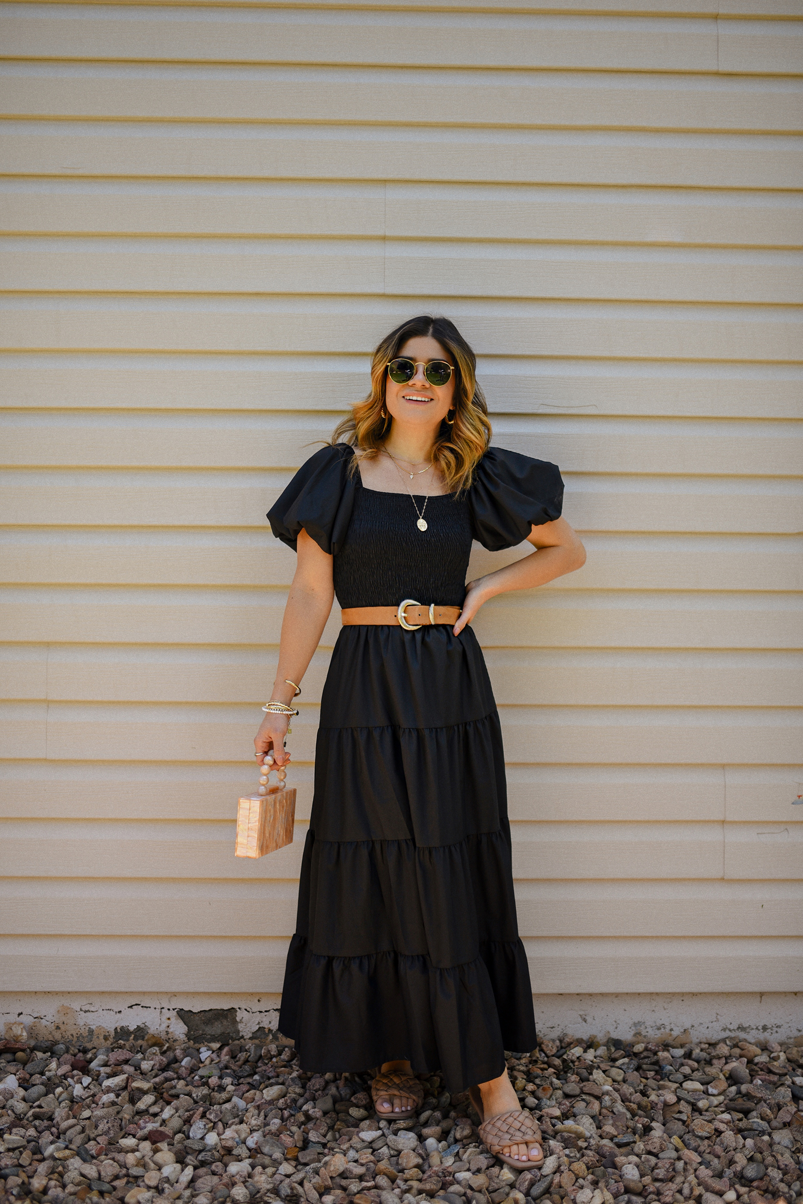 Carolina Hellal of Chic Talk wearing a blak maxi dress via Amazon, braided brown sandals, box hand bag and Ray-Ban sunglasses