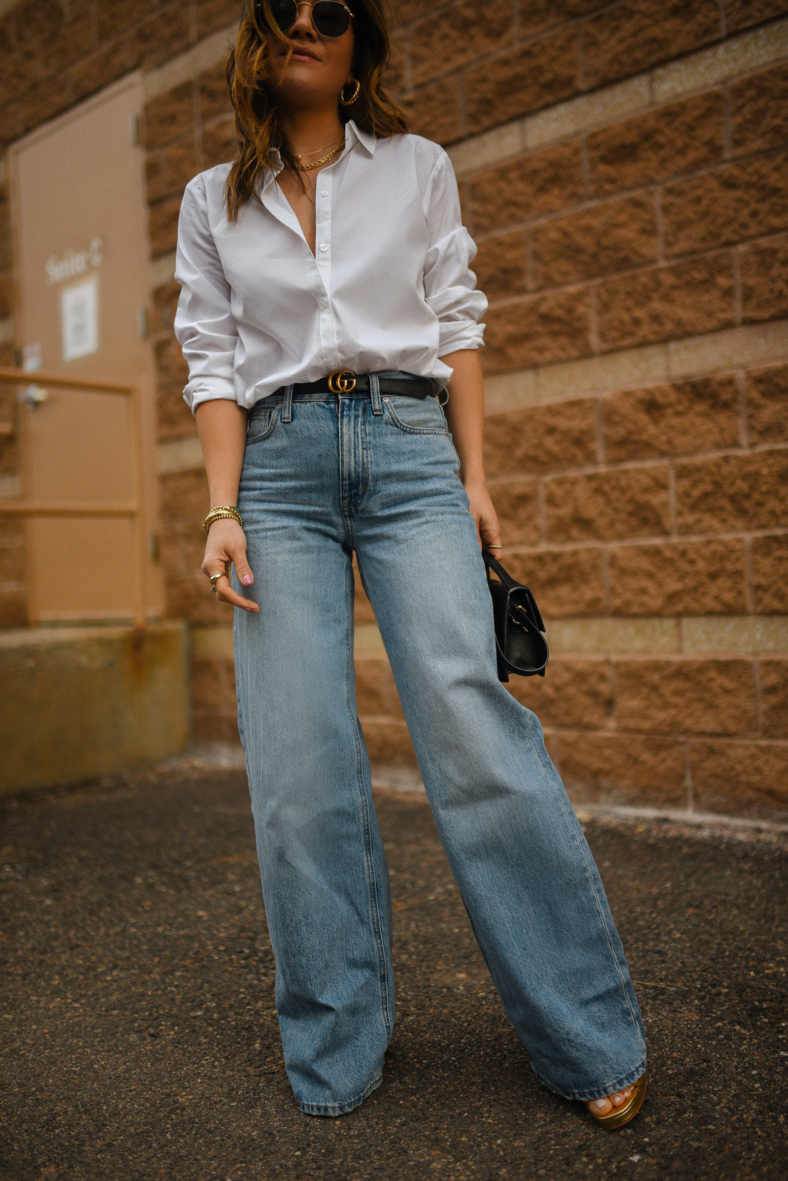 Carolina Hellal of Chic Talk wearing a beige blazer, white t-shirt, wide leg jeans via Madewell, Gucci black belt and Jacquemus bag.
