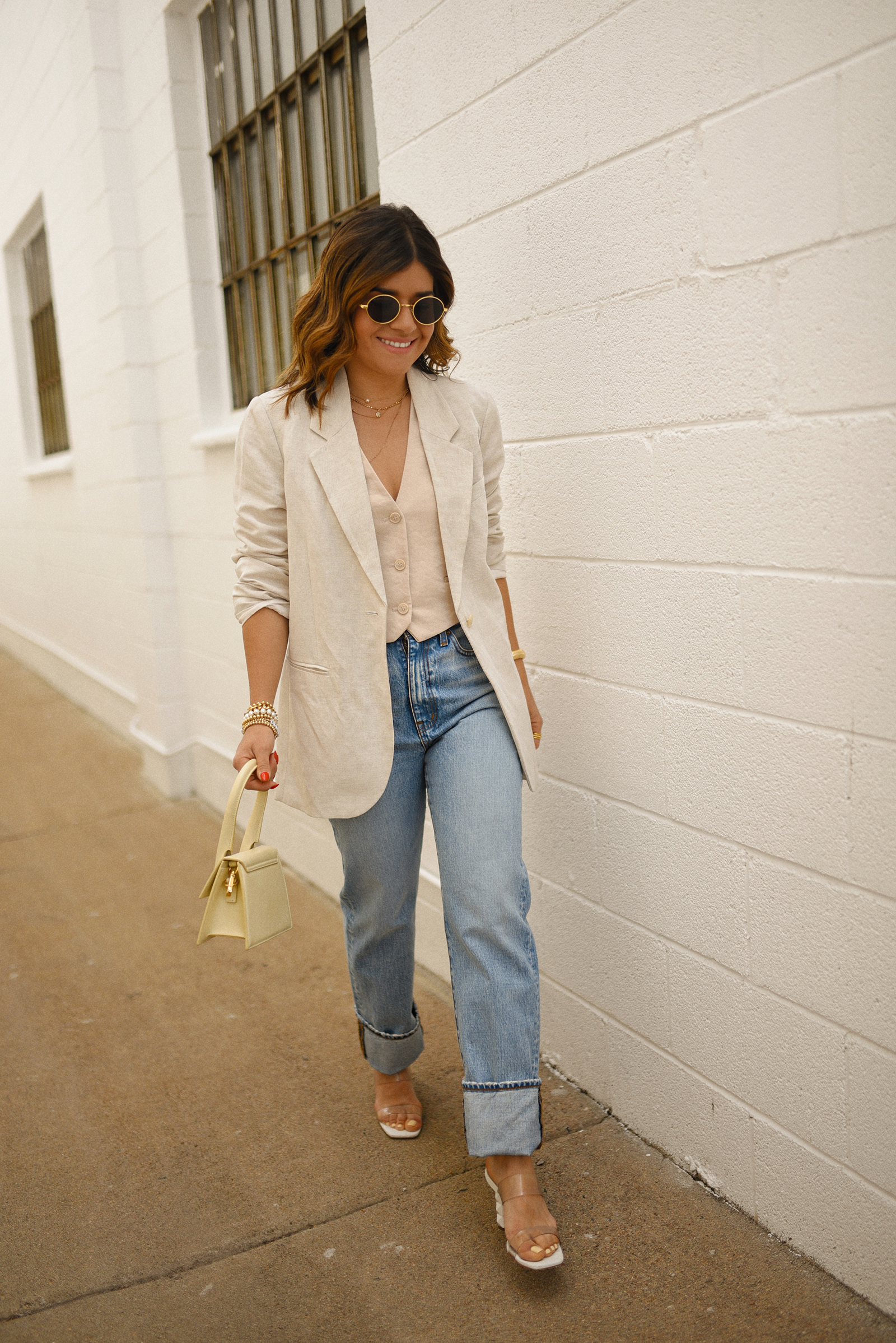 Carolina Hellal of Chic Talk wearing a Madewell jeans and vest, H&M blazer, Jacquemus hand bag and transparent sandals