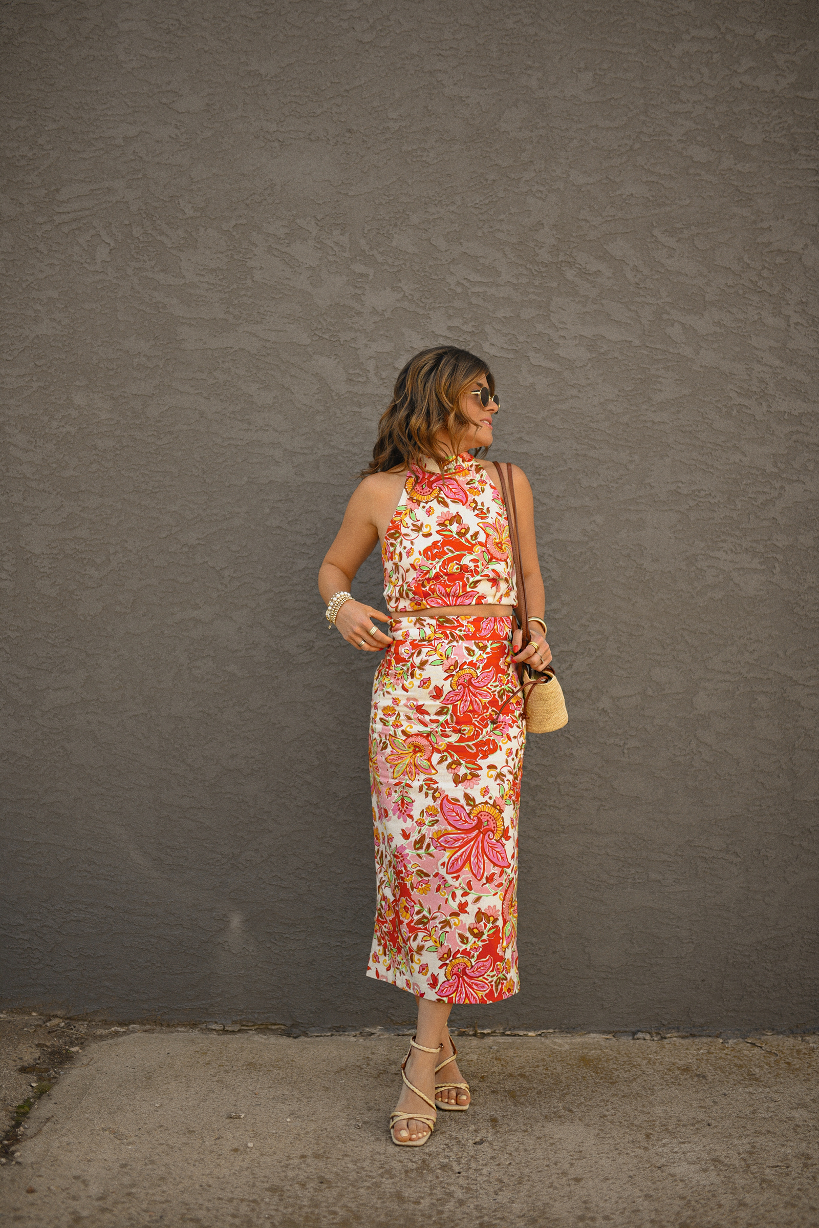 Carolina Hellal of Chic Talk wearing a Sezane floral set of top and midi skirt, a rafia bag, a Target sandals and Amazon sunglasses