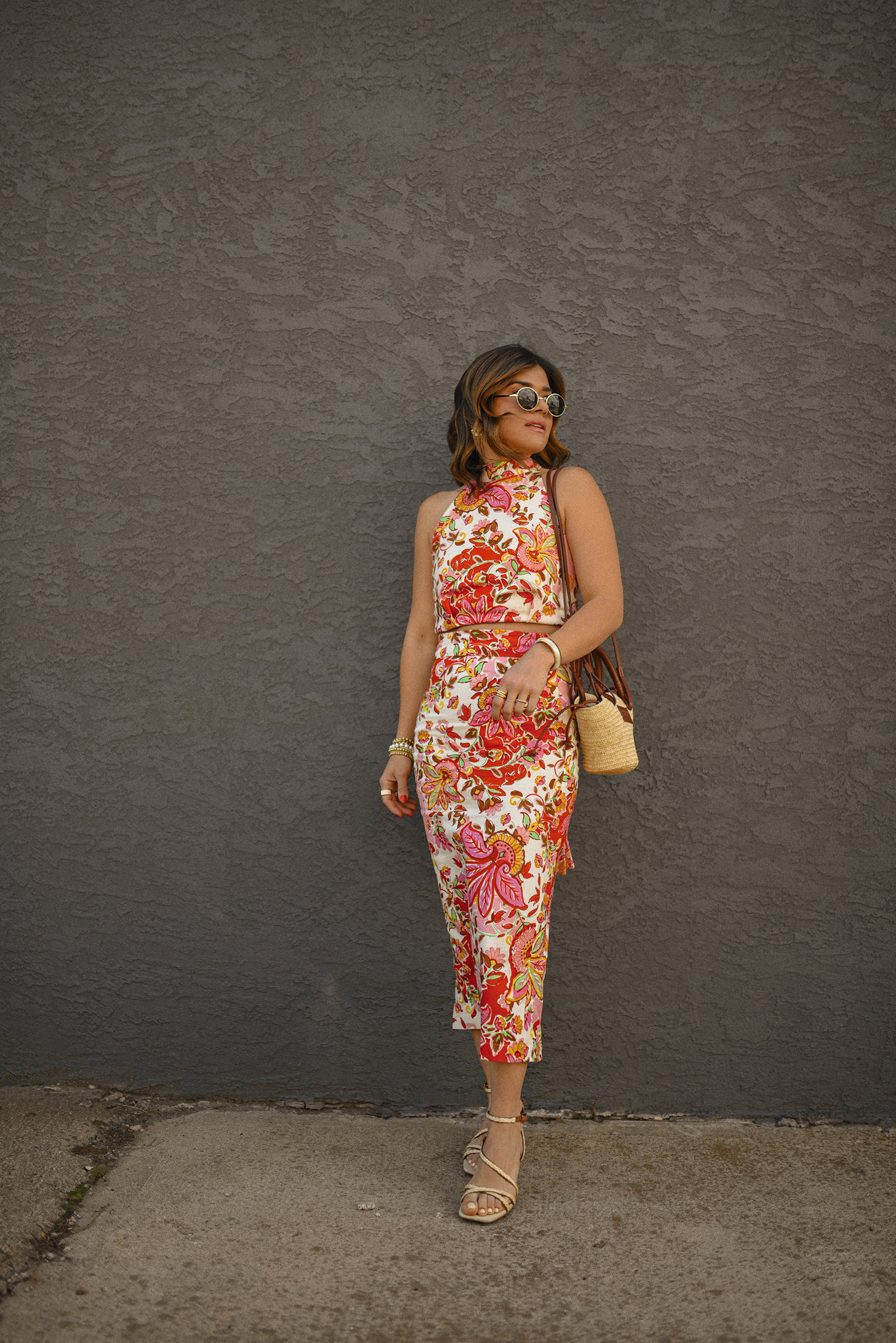 Carolina Hellal of Chic Talk wearing a Sezane floral set of top and midi skirt, a rafia bag, a Target sandals and Amazon sunglasses