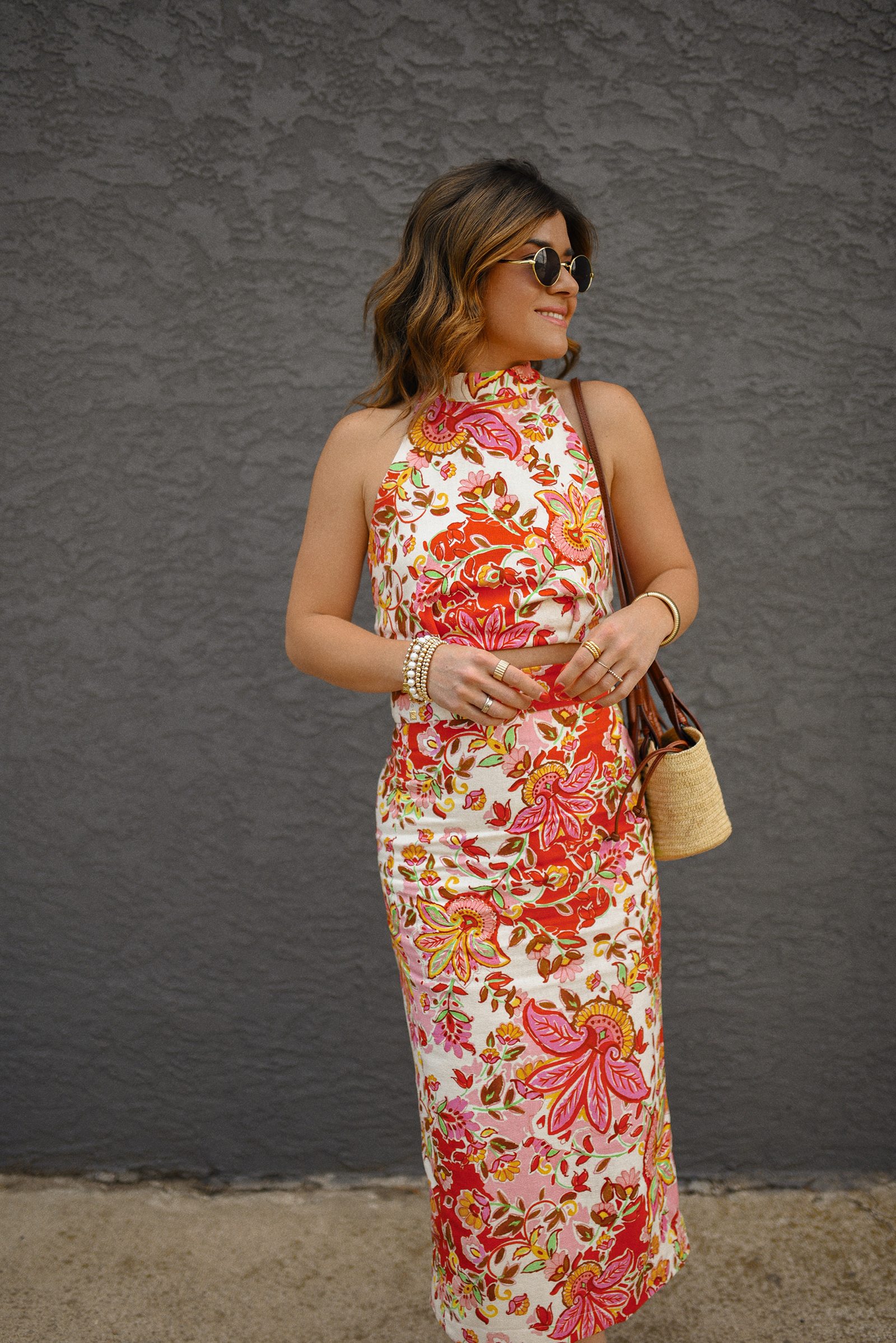 Carolina Hellal of Chic Talk wearing a Sezane floral set of top and midi skirt, a rafia bag, a Target sandals and Amazon sunglasses