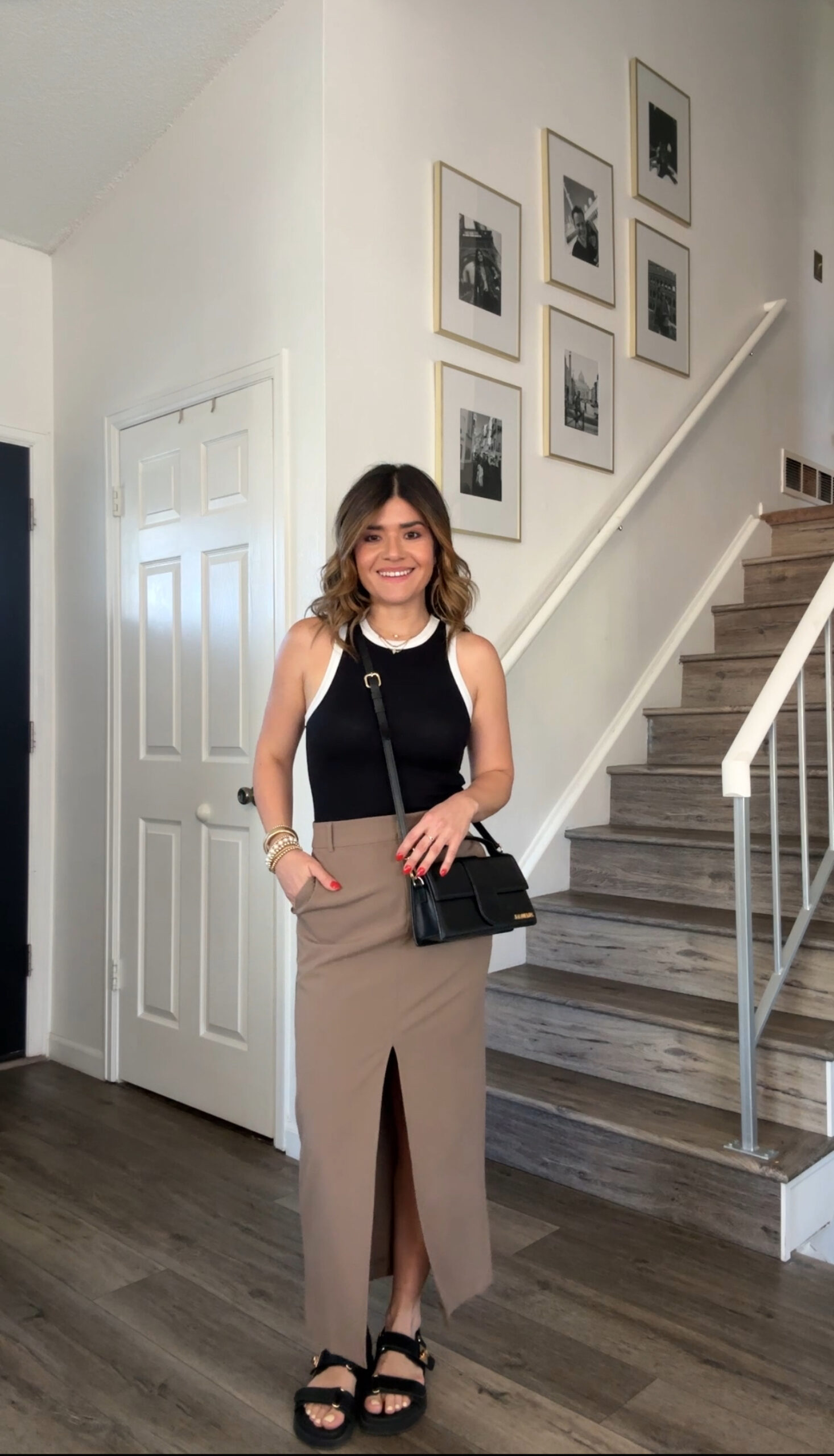 Carolina Hellal of Chic Talk wearing a nude midi skirt via Nordstrom, a black top, a Jacquemus bag and Vince Camuto sandals