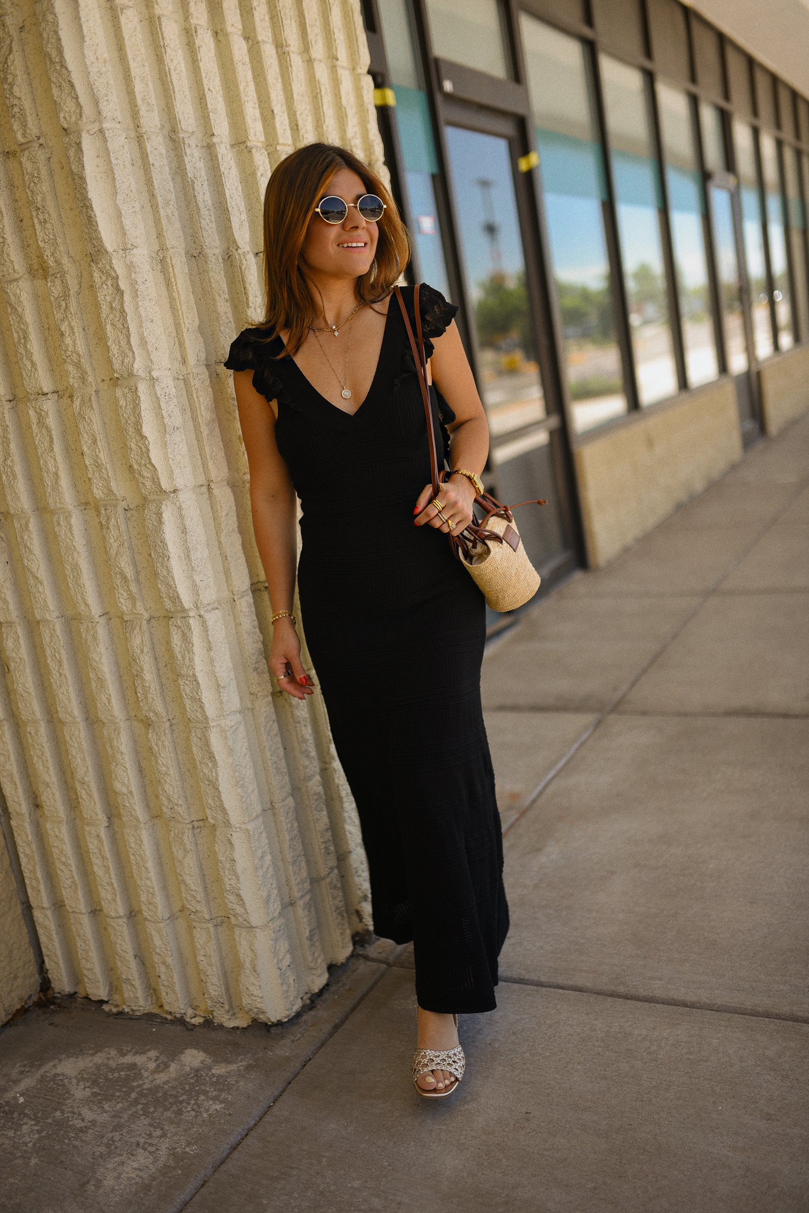 Carolina Hellal of Chic Talk wearing a black midi dress and rafia bag via Sezane