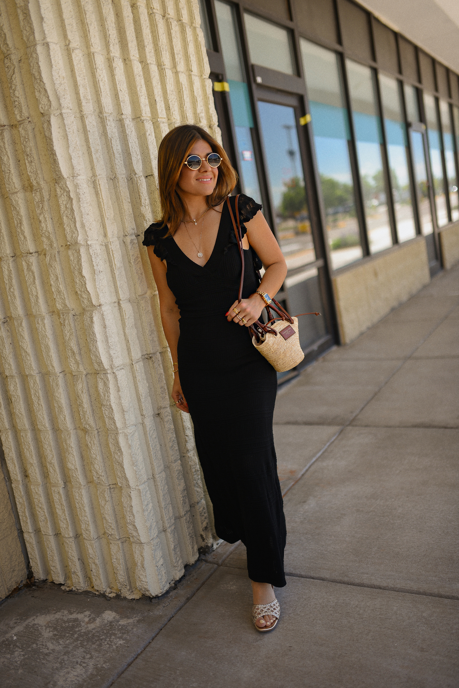 Carolina Hellal of Chic Talk wearing a black midi dress and rafia bag via Sezane