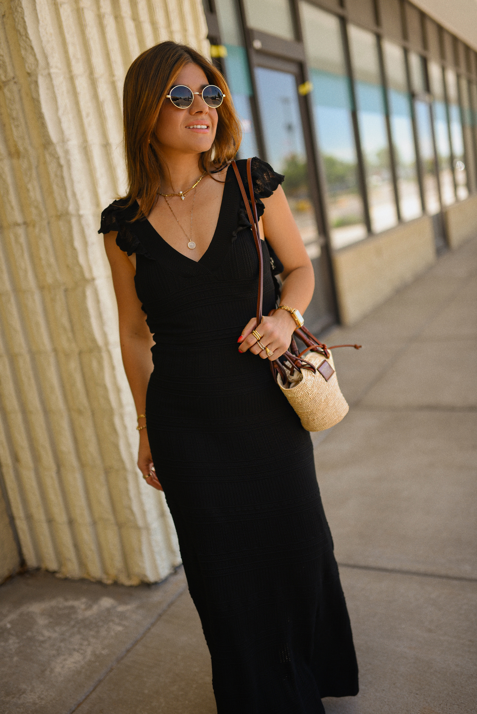 Carolina Hellal of Chic Talk wearing a black midi dress and rafia bag via Sezane