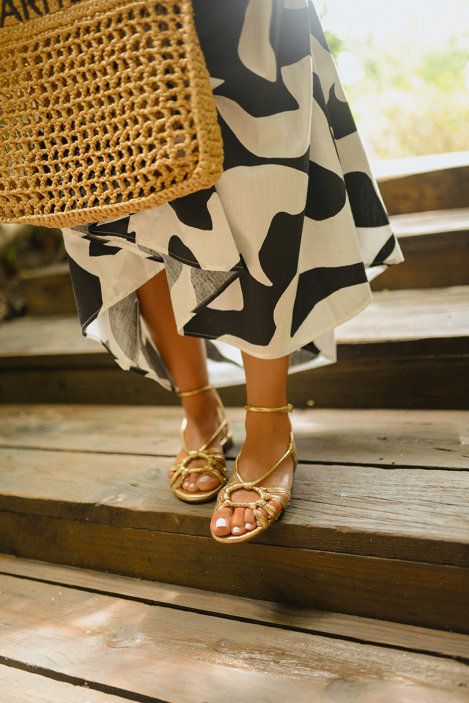 Carolina Hellal of Chic Talk wearing a Abercrombie midi dress, Aritzia raffia bag and Sezane sandals