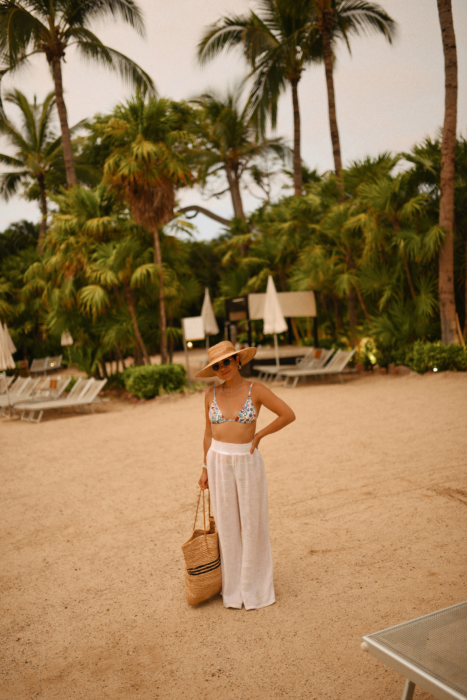 Carolina Hellal of Chic Talk wearing a Sezane bikini, Michael Stars pants, Shopbop raffia bag and hat, and Target sandals