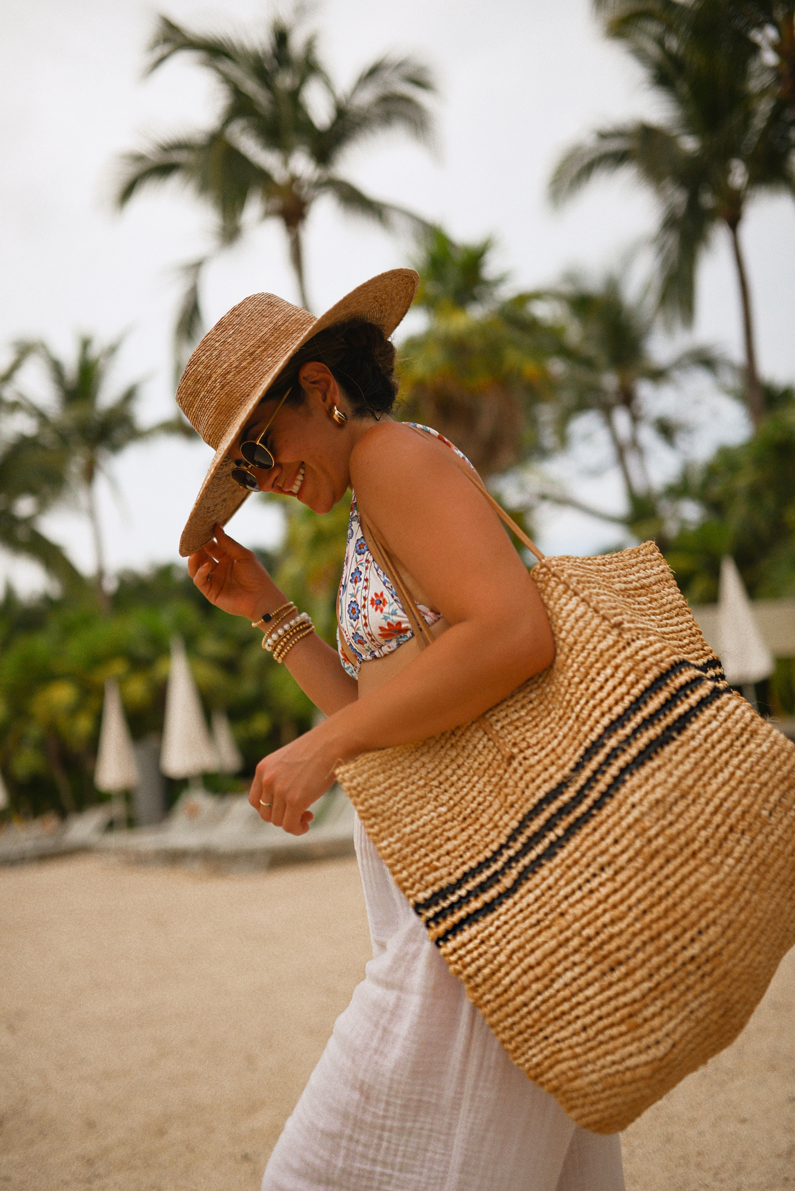 Carolina Hellal of Chic Talk wearing a Sezane bikini, Michael Stars pants, Shopbop raffia bag and hat, and Target sandals