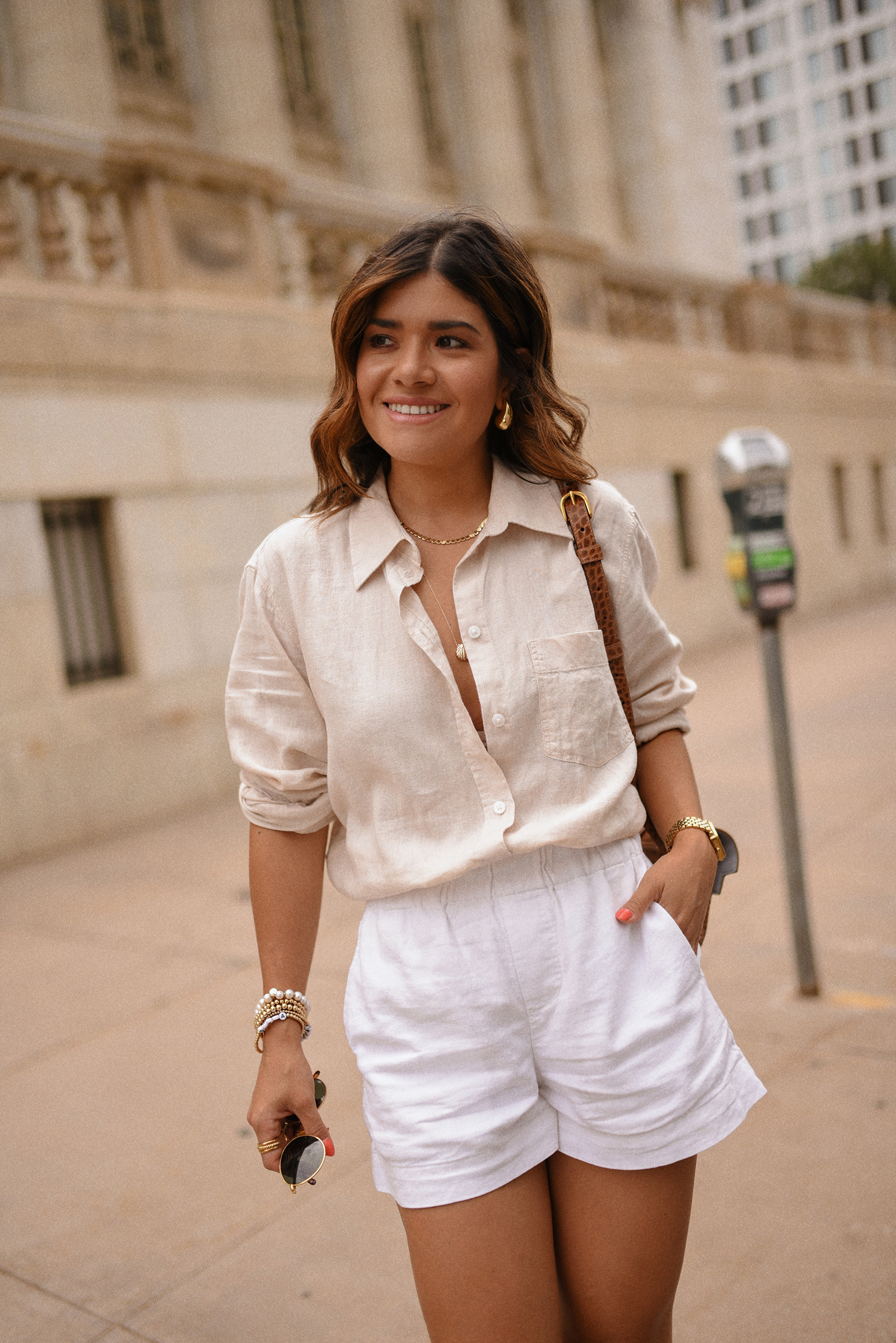 Carolina Hellal of Chic Talk wearing a white shorts via Target, H&M linen shirt, Sezane sandals and Senreve Aria handbag