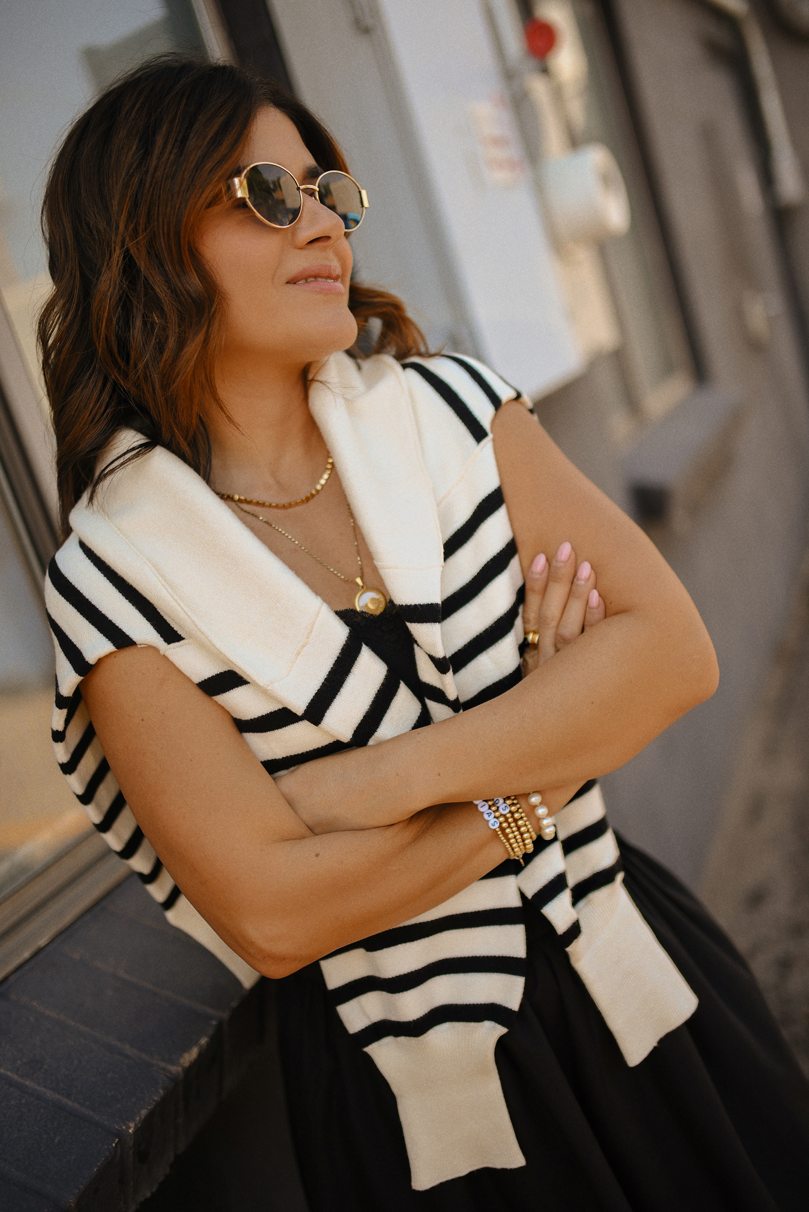 Carolina Hellal of Chic Talk wearing a bubble hem maxi skirt, a stripped sweater, a mesh Mary Jane flats and sunglasses via Amazon, a black crop top from Target and red handbag via Anthropologie