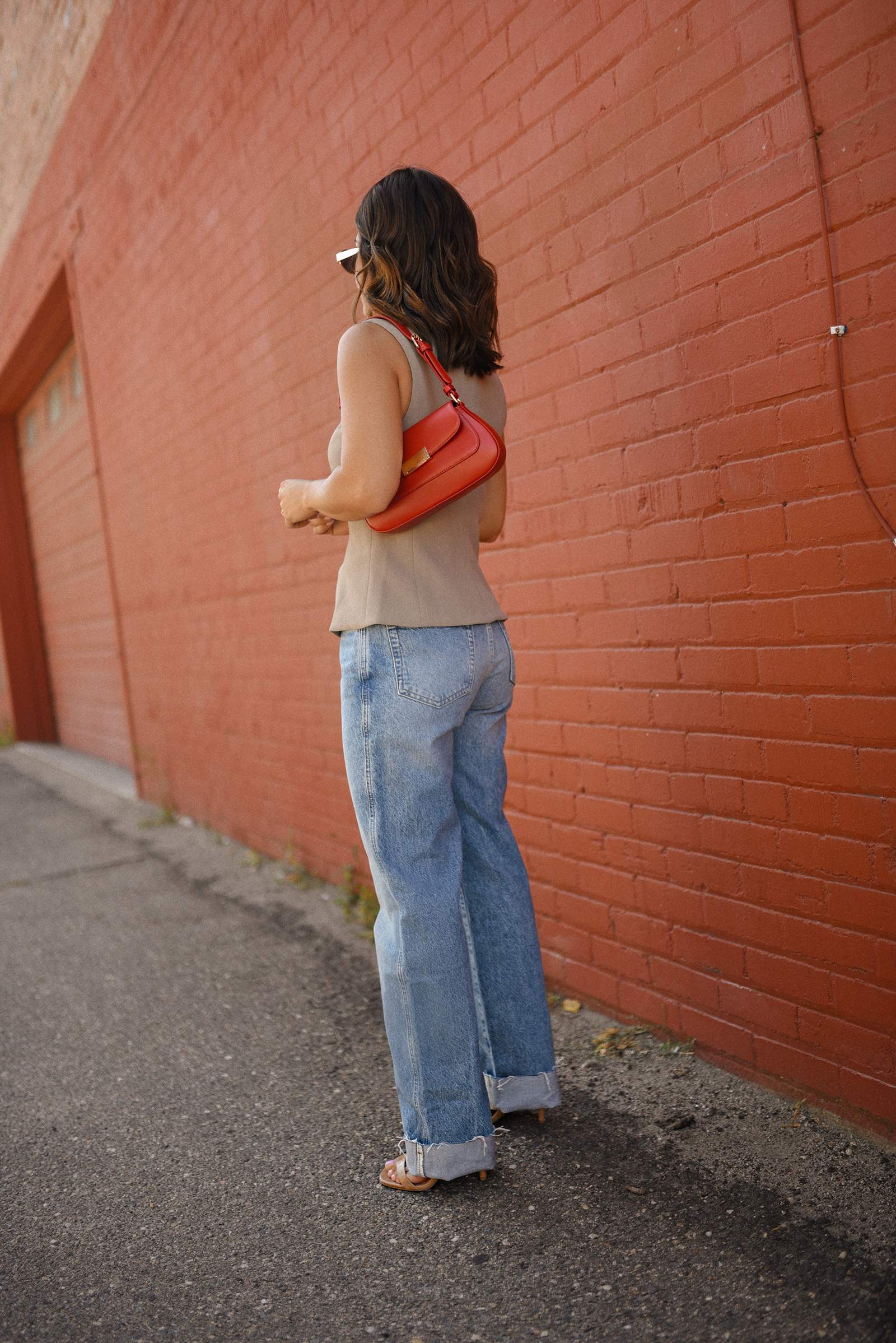 Carolina Hellal of Chic Talk wearing a Aritzia vest and blazer, Reformation wide leg jeans and Anrthropologie hand bag