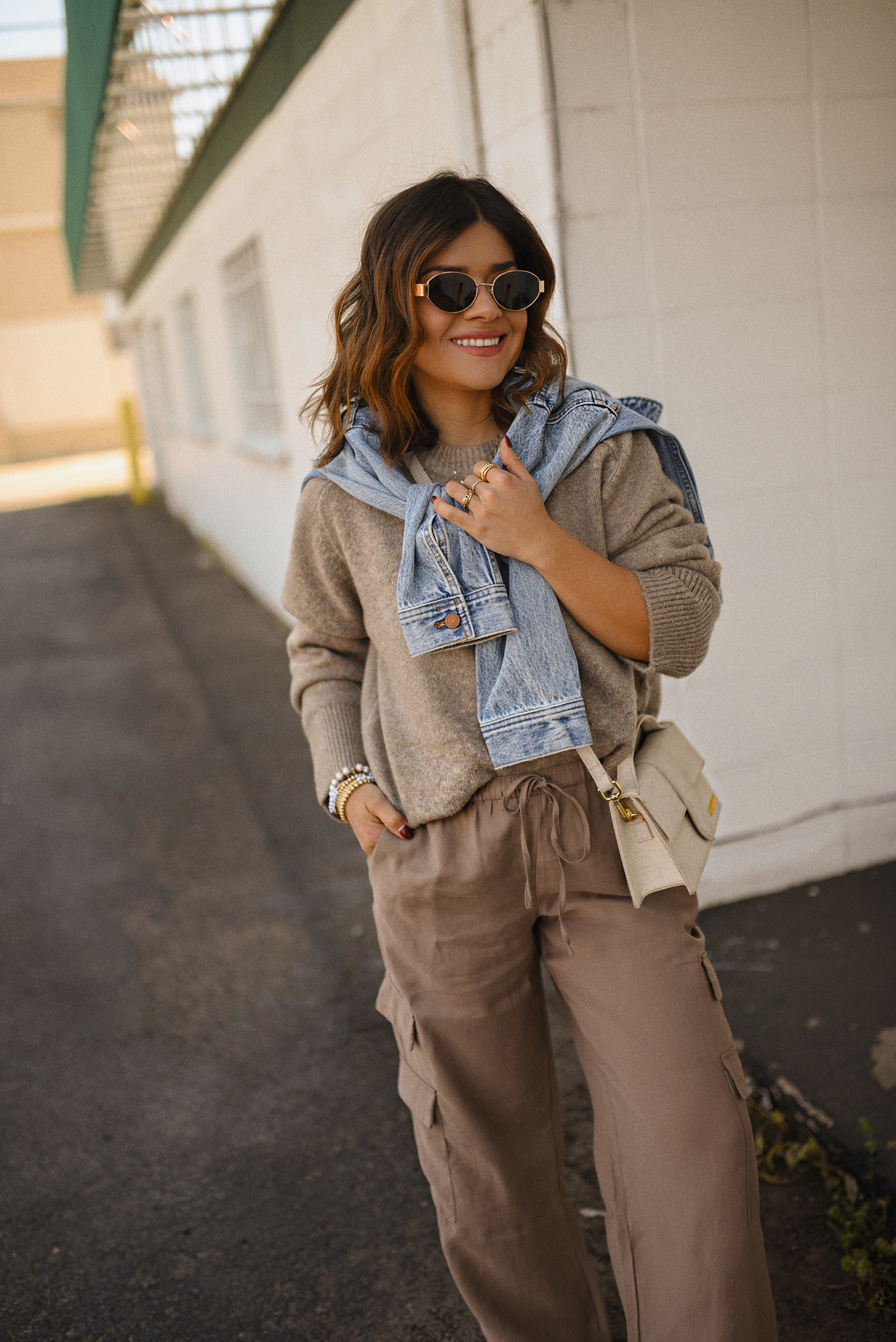 Carolina Hellal of Chic Talk wearing a cargo pants and sweater via Abercrombie, a classic jean jacket, Adidas Samba Shoes and Jacquemus Le Grand Bambino bag