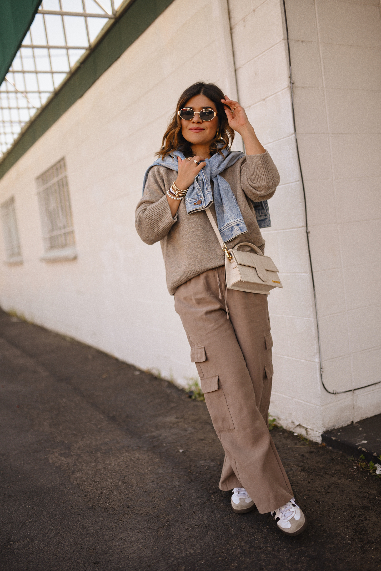 Carolina Hellal of Chic Talk wearing a cargo pants and sweater via Abercrombie, a classic jean jacket, Adidas Samba Shoes and Jacquemus Le Grand Bambino bag