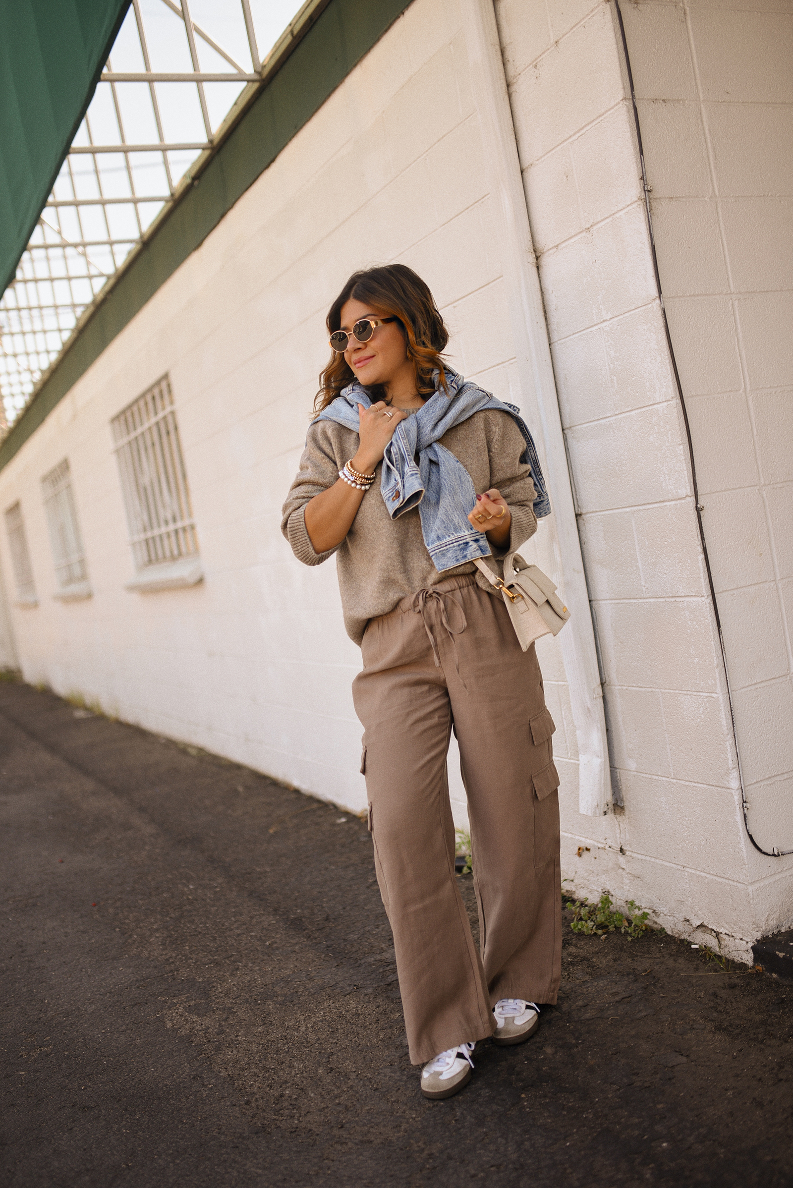 Carolina Hellal of Chic Talk wearing a cargo pants and sweater via Abercrombie, a classic jean jacket, Adidas Samba Shoes and Jacquemus Le Grand Bambino bag