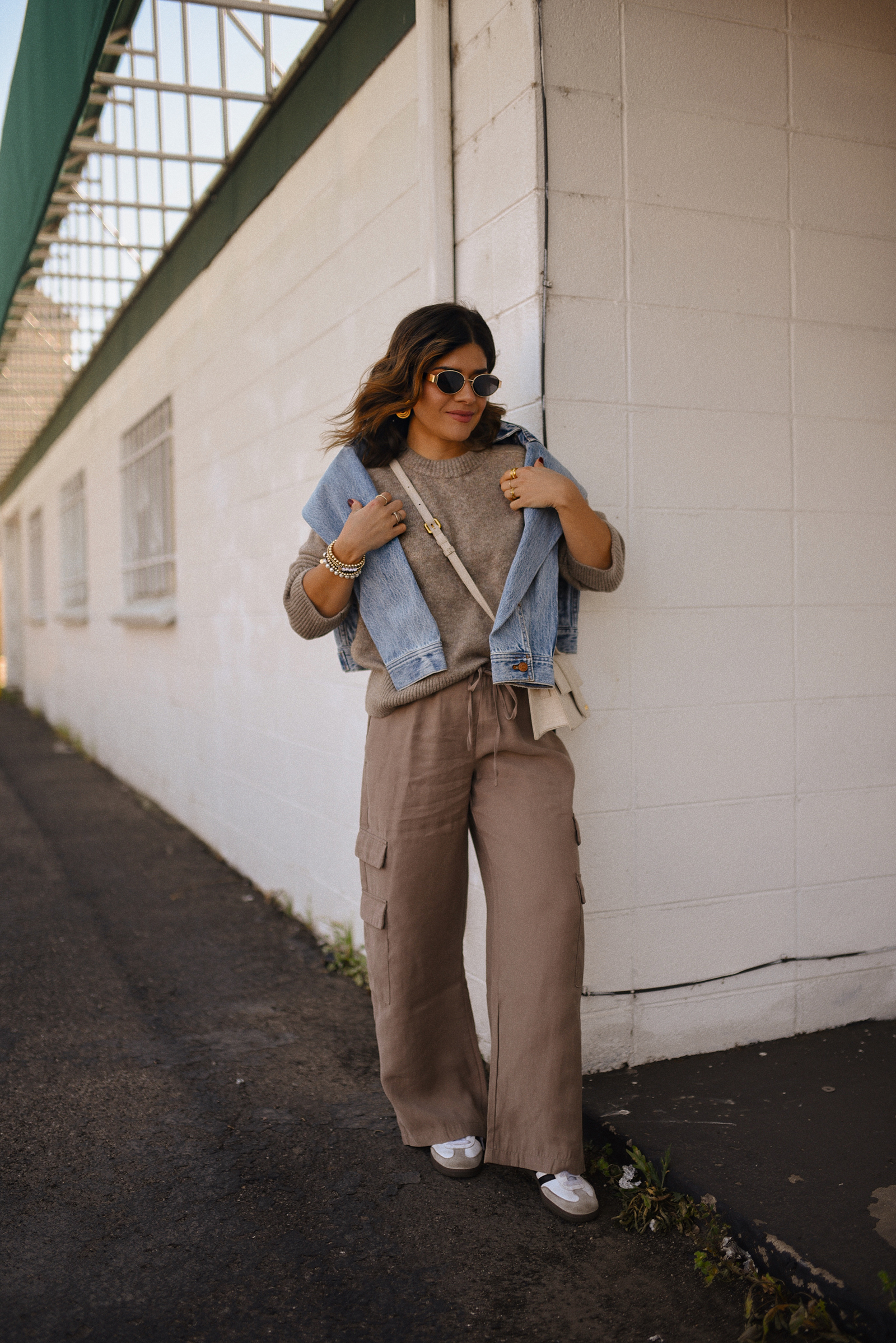 Carolina Hellal of Chic Talk wearing a cargo pants and sweater via Abercrombie, a classic jean jacket, Adidas Samba Shoes and Jacquemus Le Grand Bambino bag