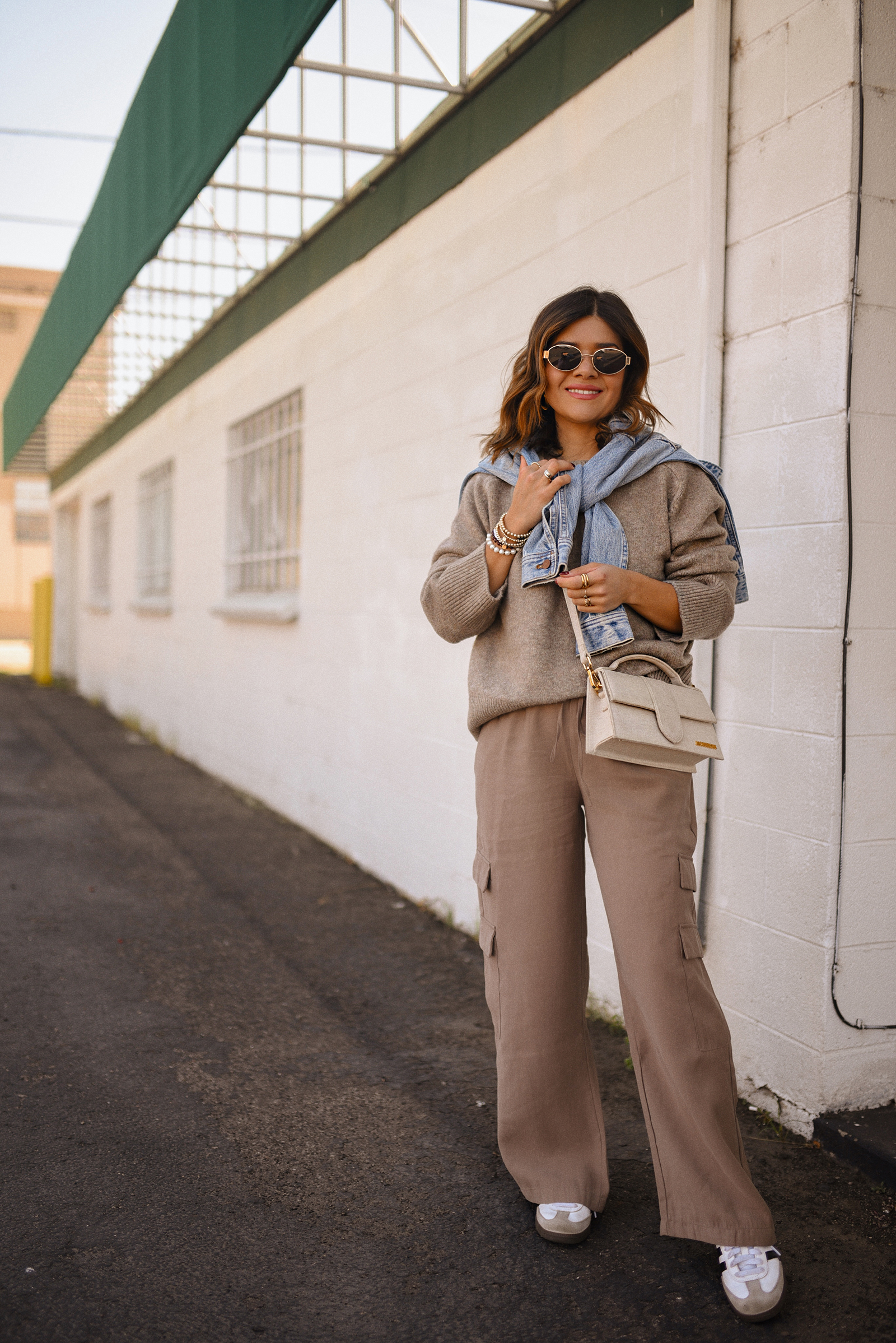 Carolina Hellal of Chic Talk wearing a cargo pants and sweater via Abercrombie, a classic jean jacket, Adidas Samba Shoes and Jacquemus Le Grand Bambino bag