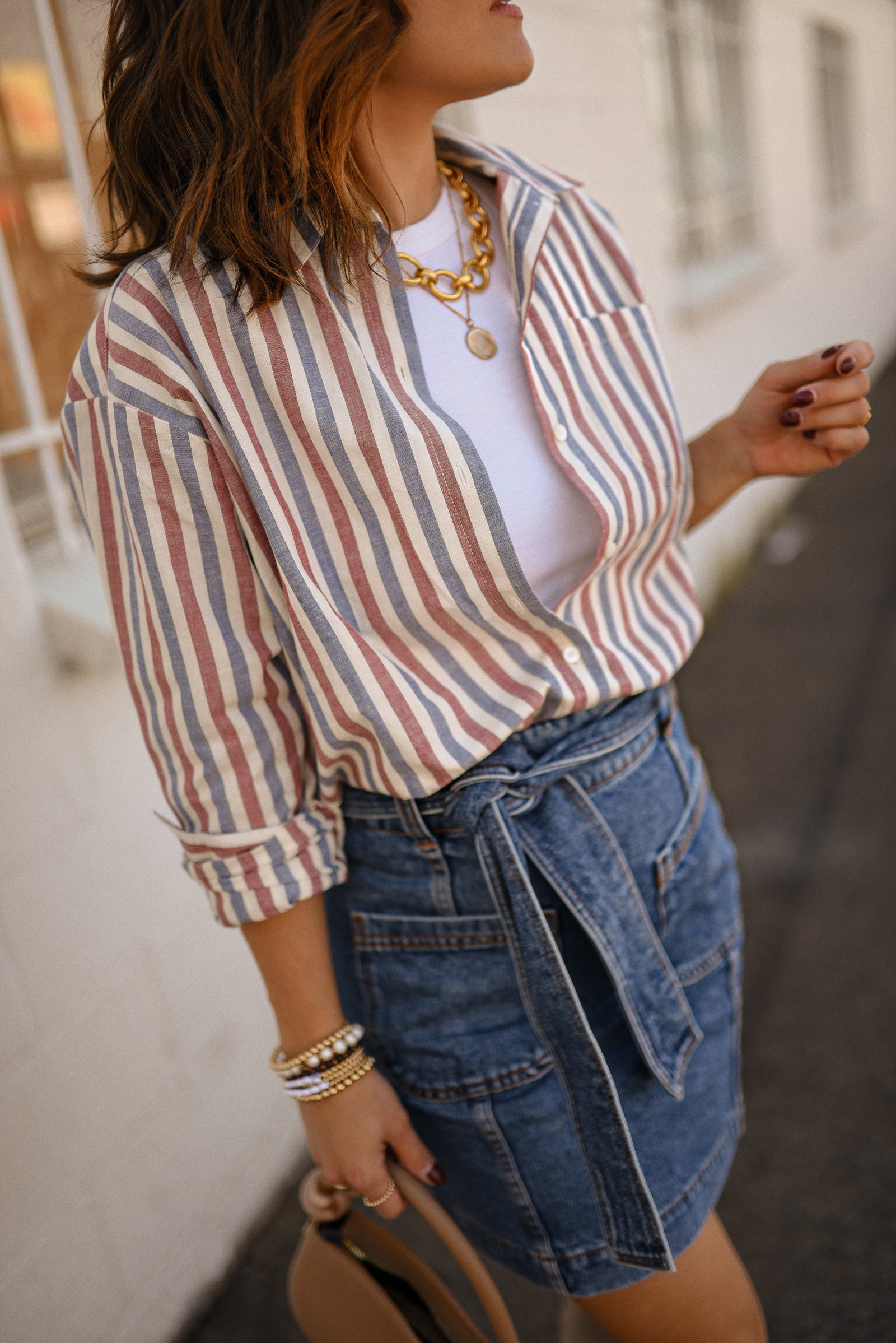 Carolina Hellal of Chic Talk wearing a total look via Sezane, denim mini skirt and stripped shirt, Nordstrom nude boots, and nude handbag